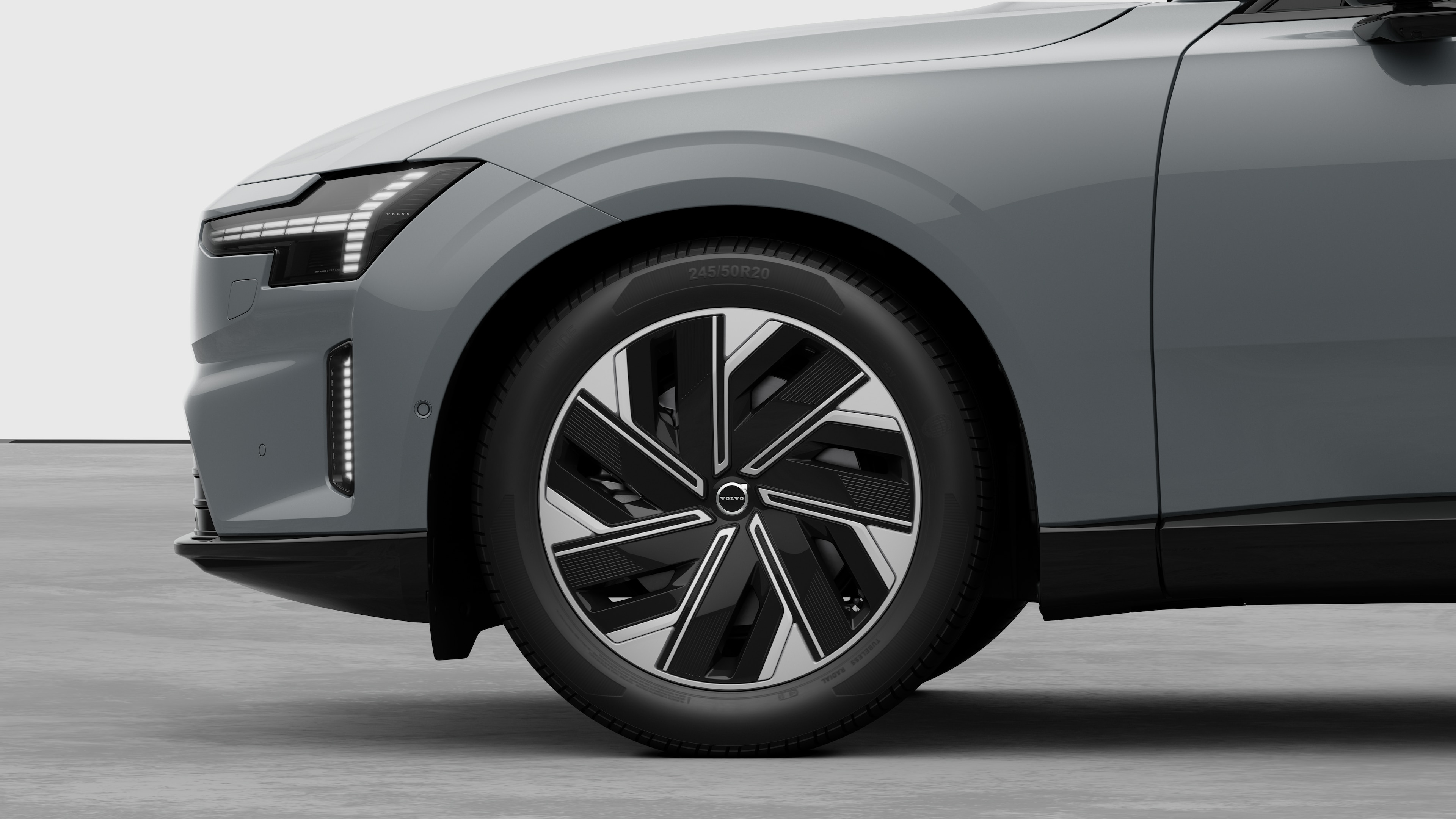 Volvo car exterior side view focusing on the front wheel and fender, set against a plain studio background.