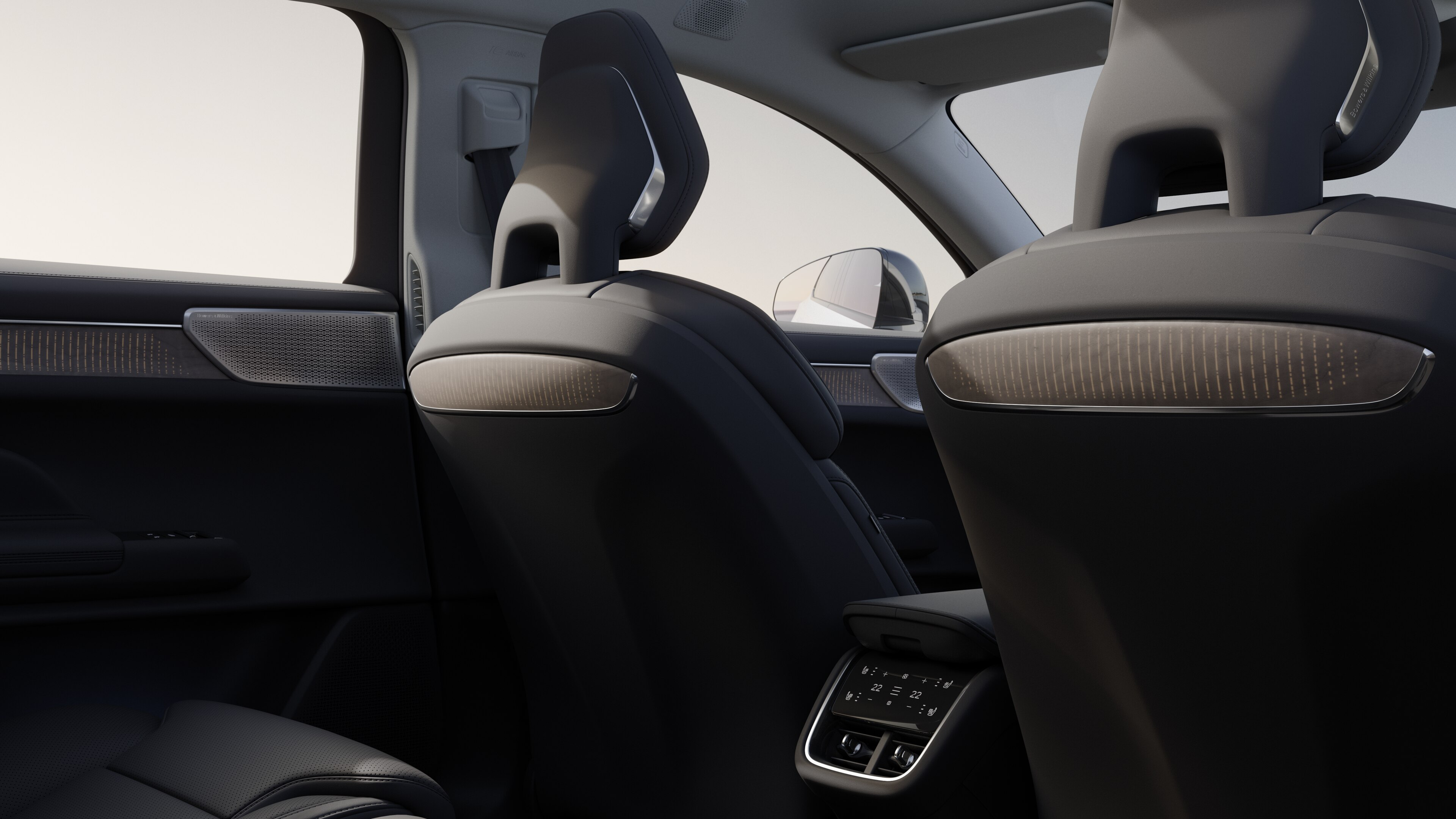 Volvo car interior rear passenger seat view showing rear seats and part of the side panel, with plain studio background visible through windows.