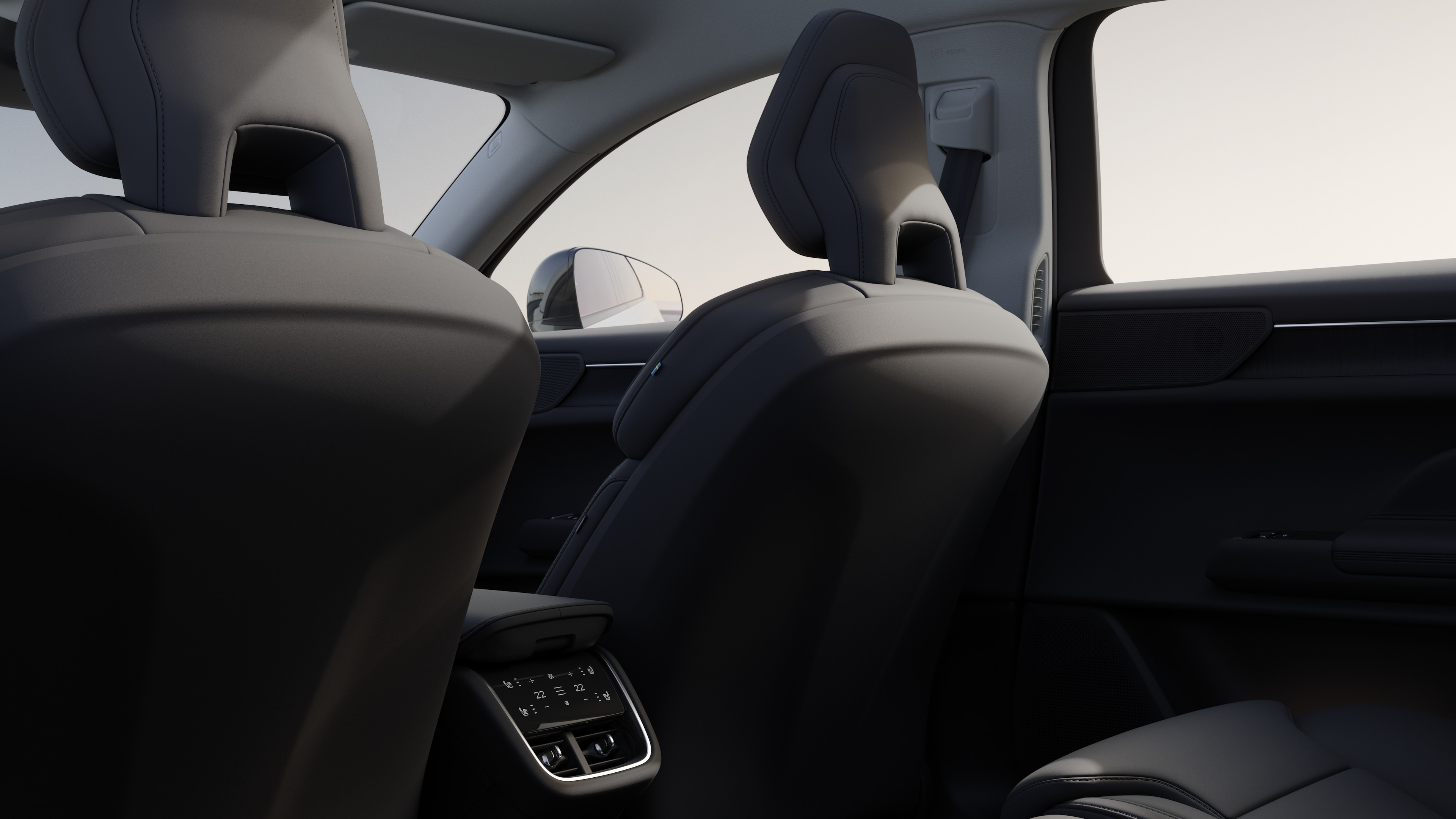 Innenansicht des Beifahrersitzes eines Volvo-Fahrzeugs, die Rücksitze und einen Teil der Seitenverkleidung zeigt, mit einem einfachen Studiohintergrund, der durch die Fenster sichtbar ist.