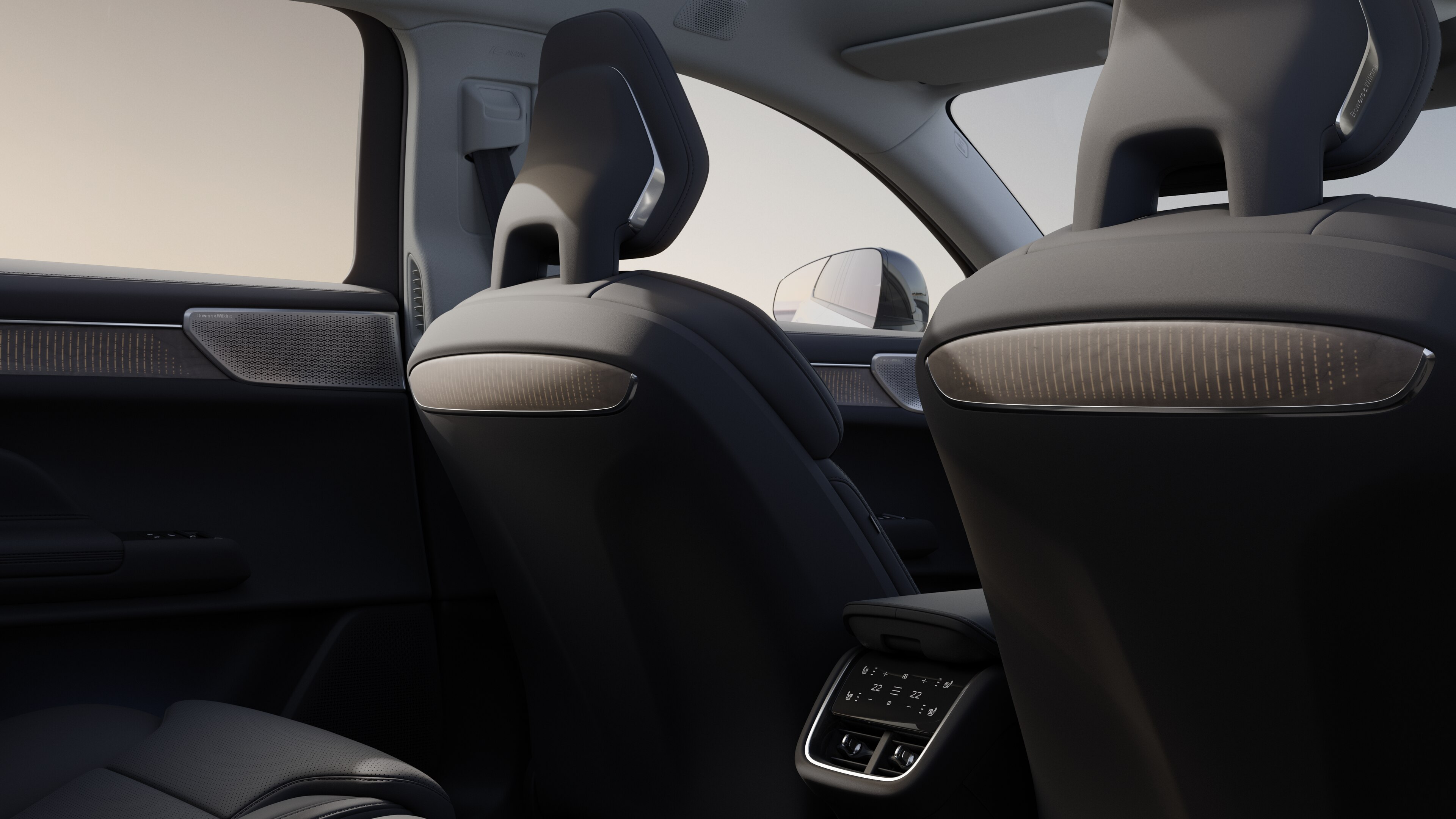 Volvo car interior rear passenger seat view showing rear seats and part of the side panel, with plain studio background visible through windows.