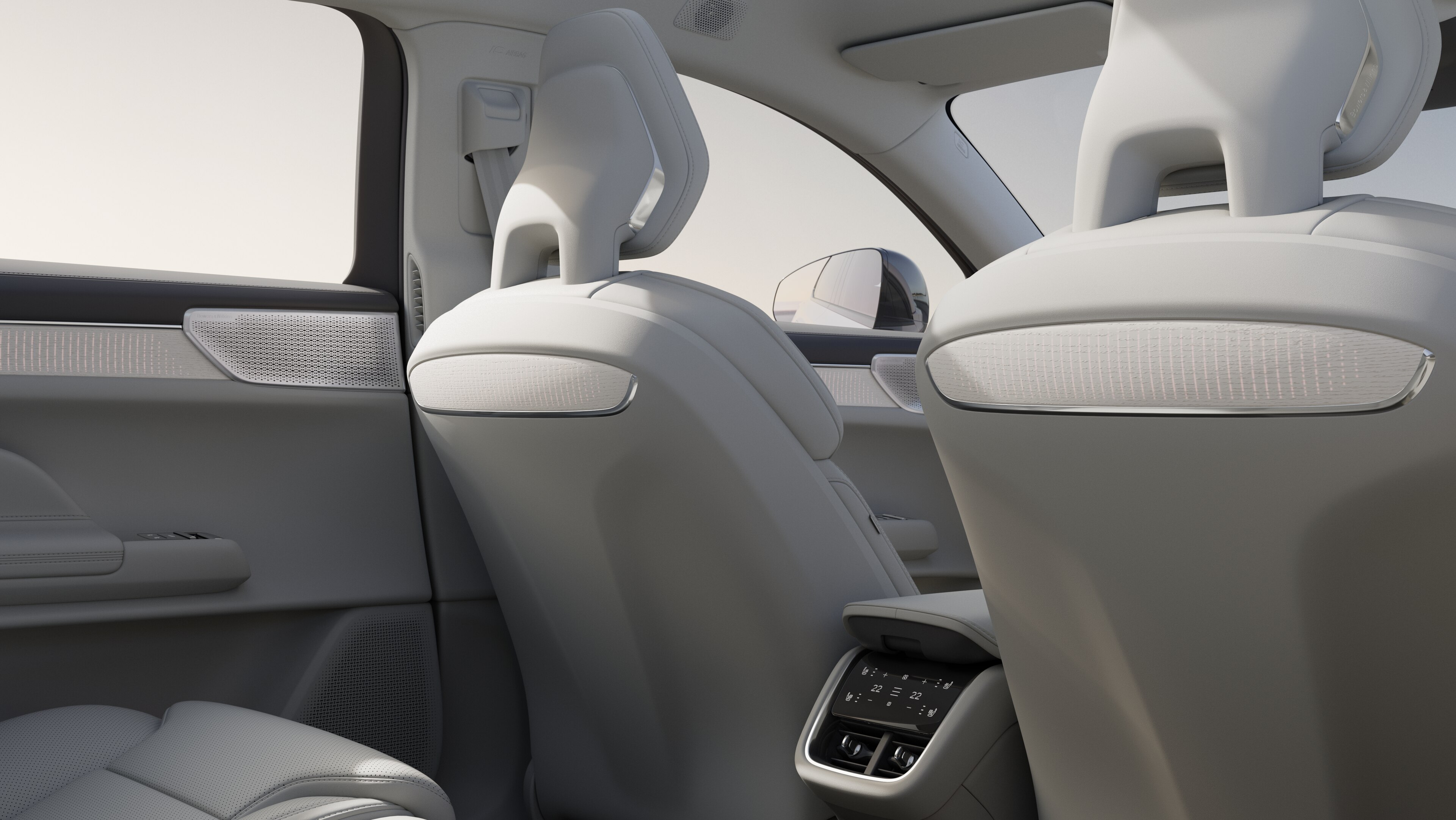 Volvo car interior rear passenger seat view showing rear seats and part of the side panel, with plain studio background visible through windows.