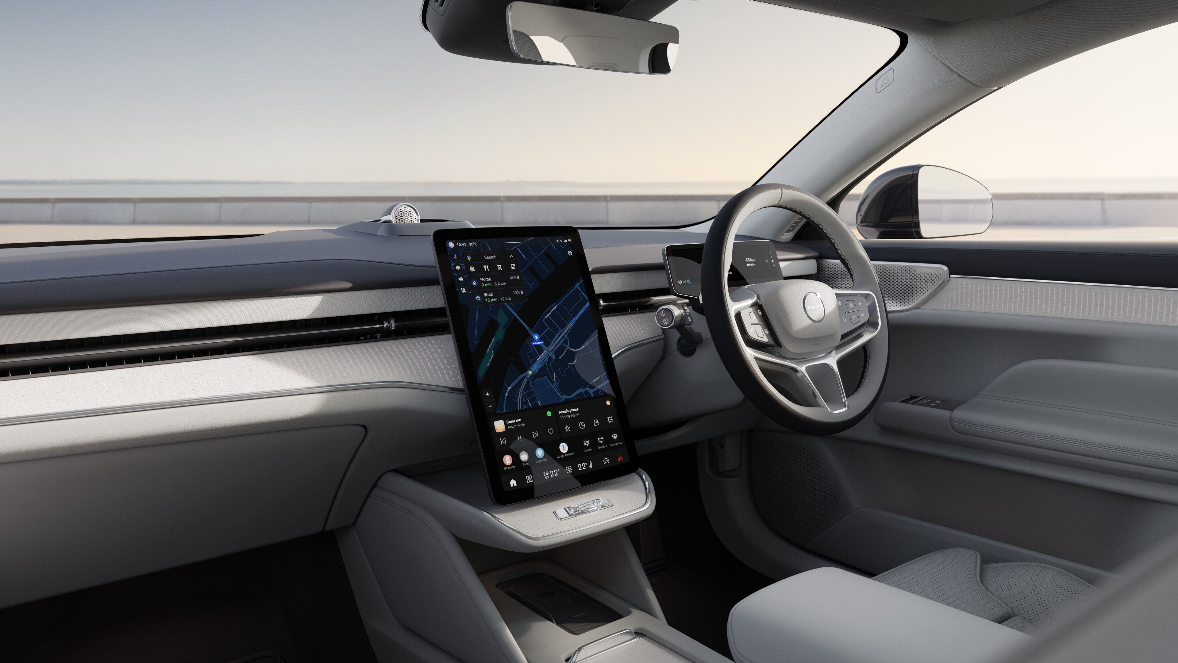 Volvo car interior showing dashboard, steering wheel, and center console with digital display in an open road background.