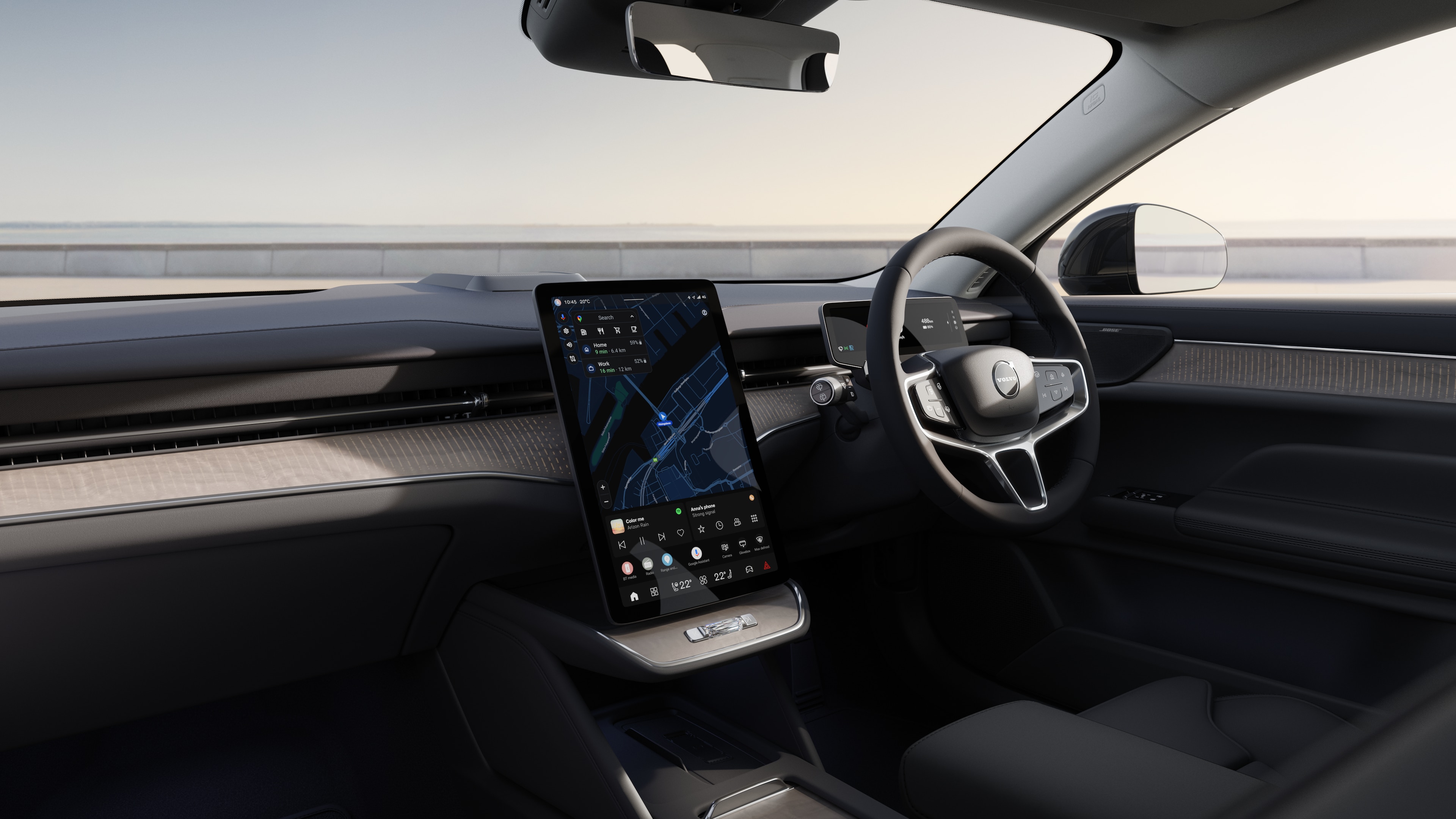 Volvo car interior showing dashboard, steering wheel, and center console with digital display in an open road background.