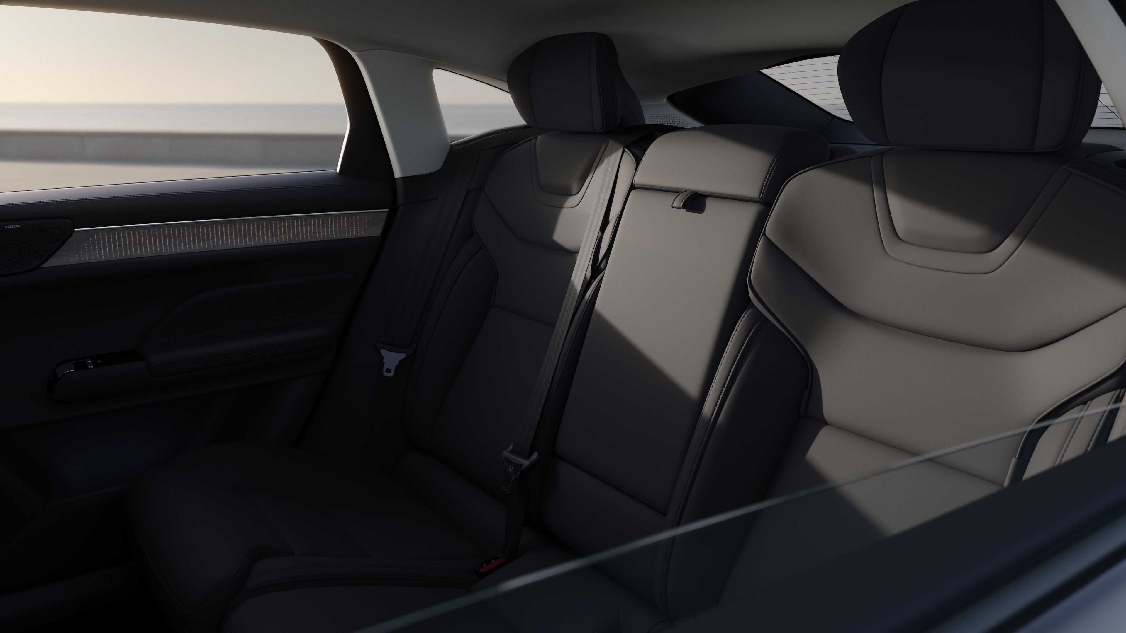 Volvo car interior showing front and rear passenger seats, steering wheel, dashboard, and center console against a plain studio background.