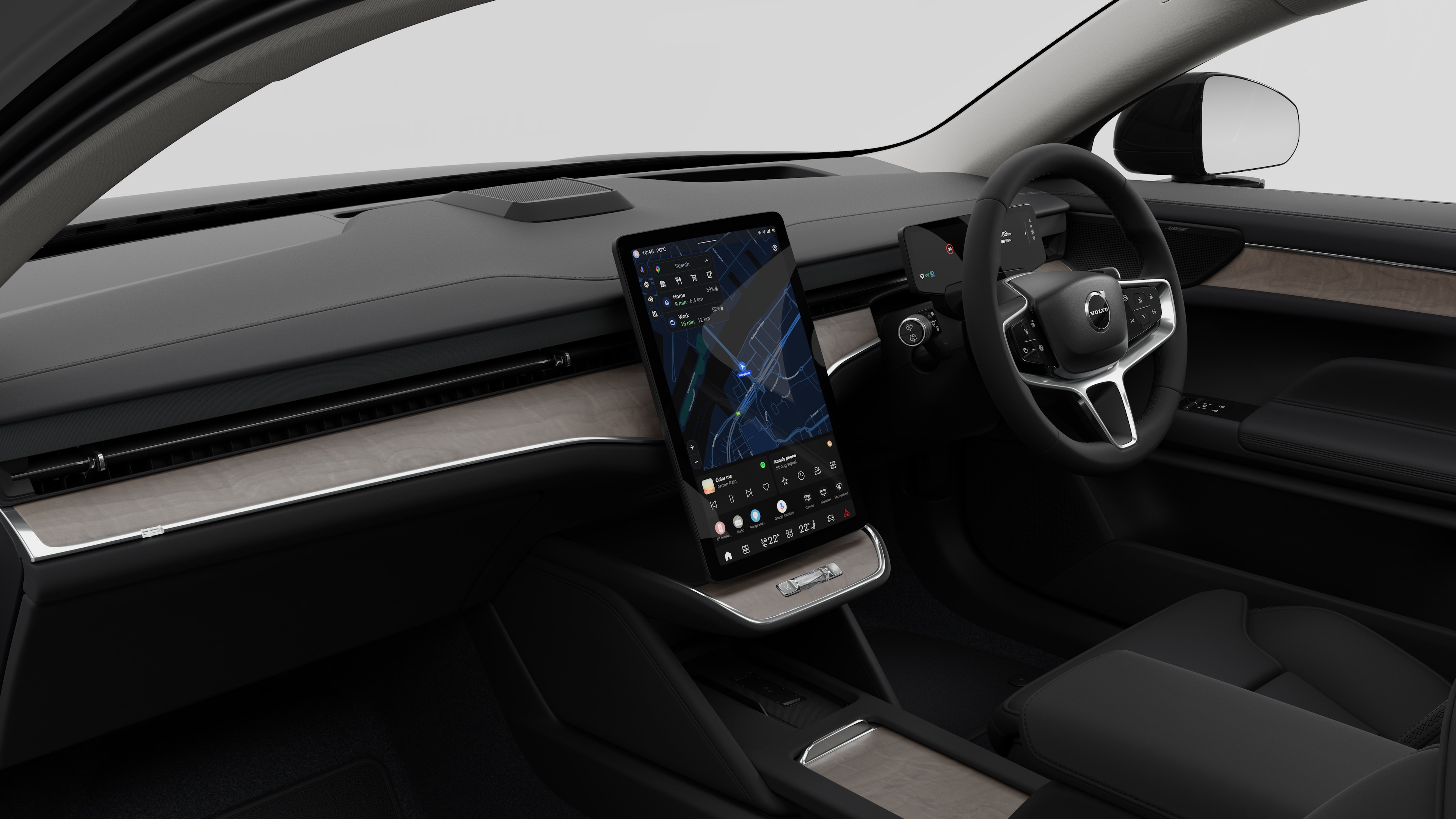 Interior view of a Volvo car showing the dashboard, steering wheel, center console, and digital display screen in a plain studio background.