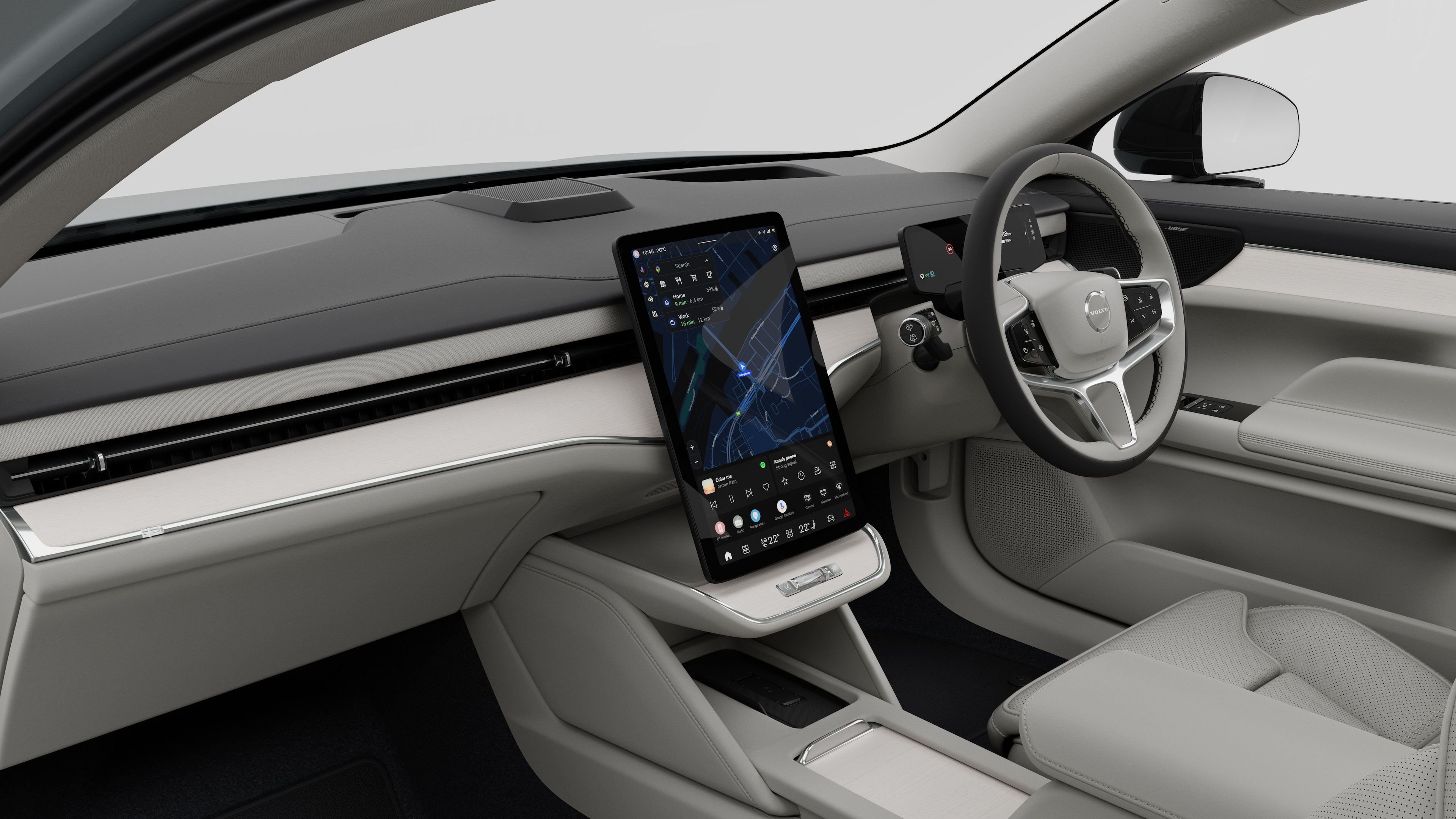 Interior view of a Volvo car showing the dashboard, steering wheel, center console, and digital display screen in a plain studio background.