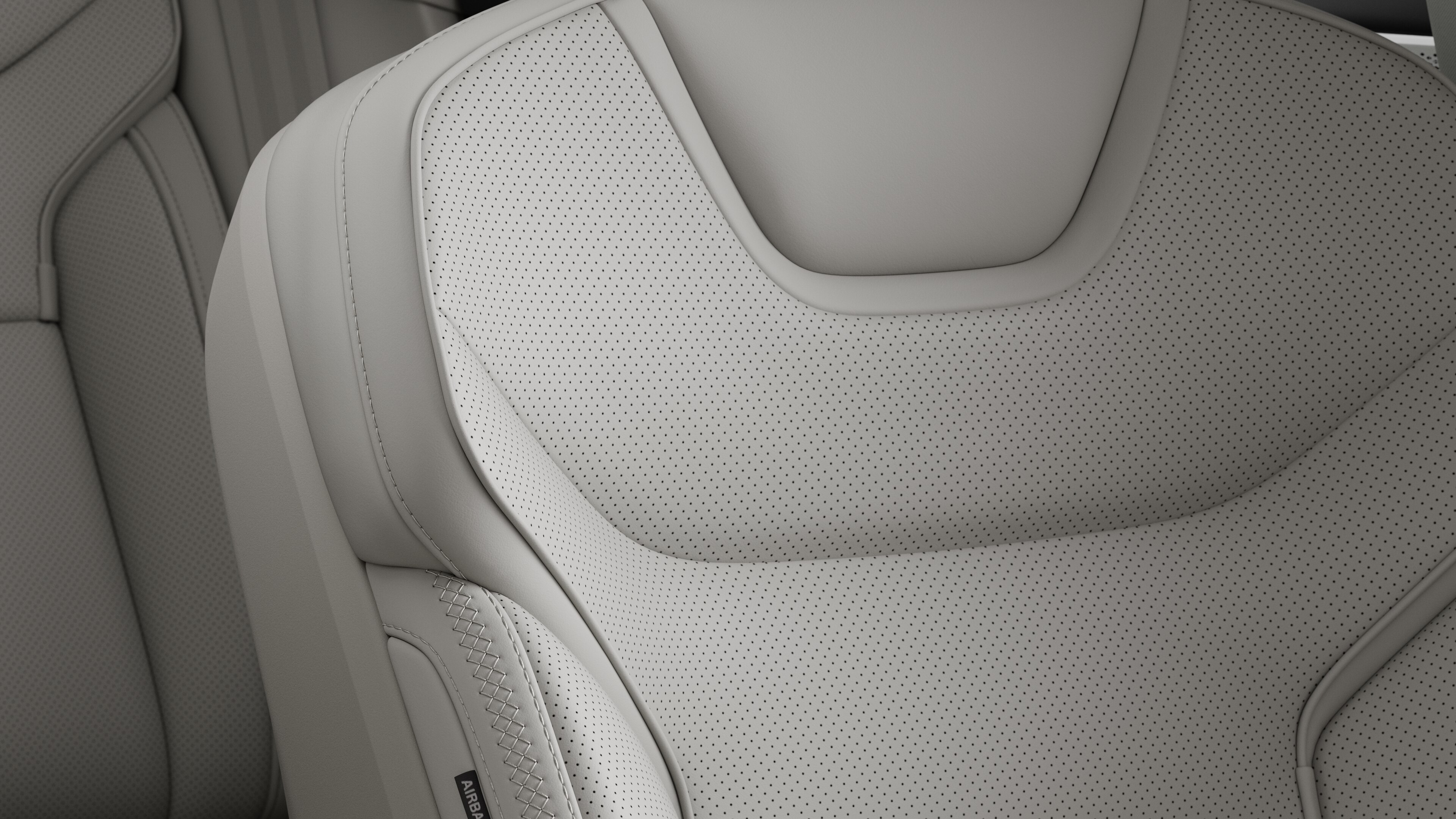 Close-up of Volvo car interior seat detail showing stitching and a small Swedish flag tag.