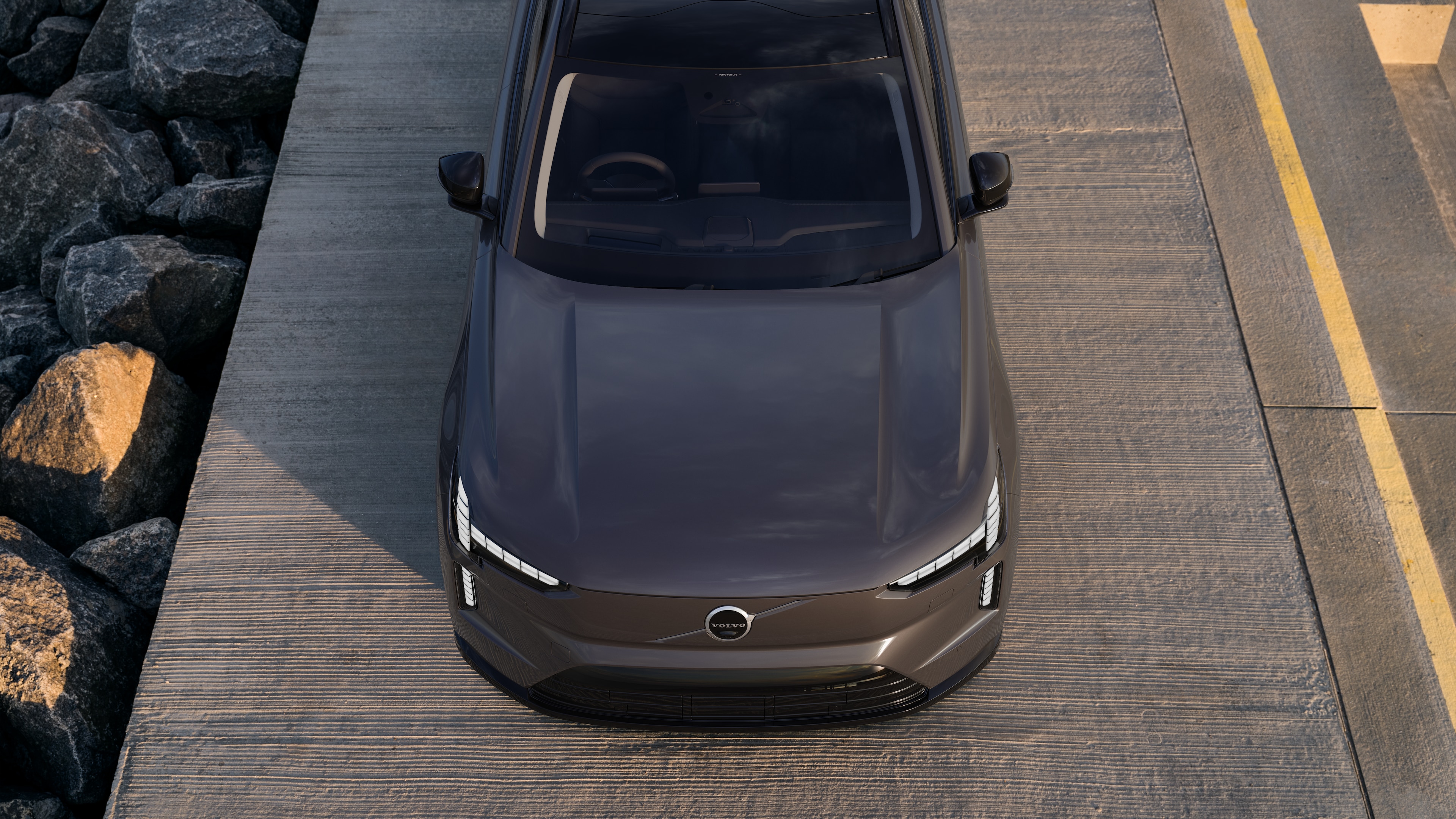 Volvo car exterior in three-quarter view on an urban street background, showing one side, roof, and part of the front.