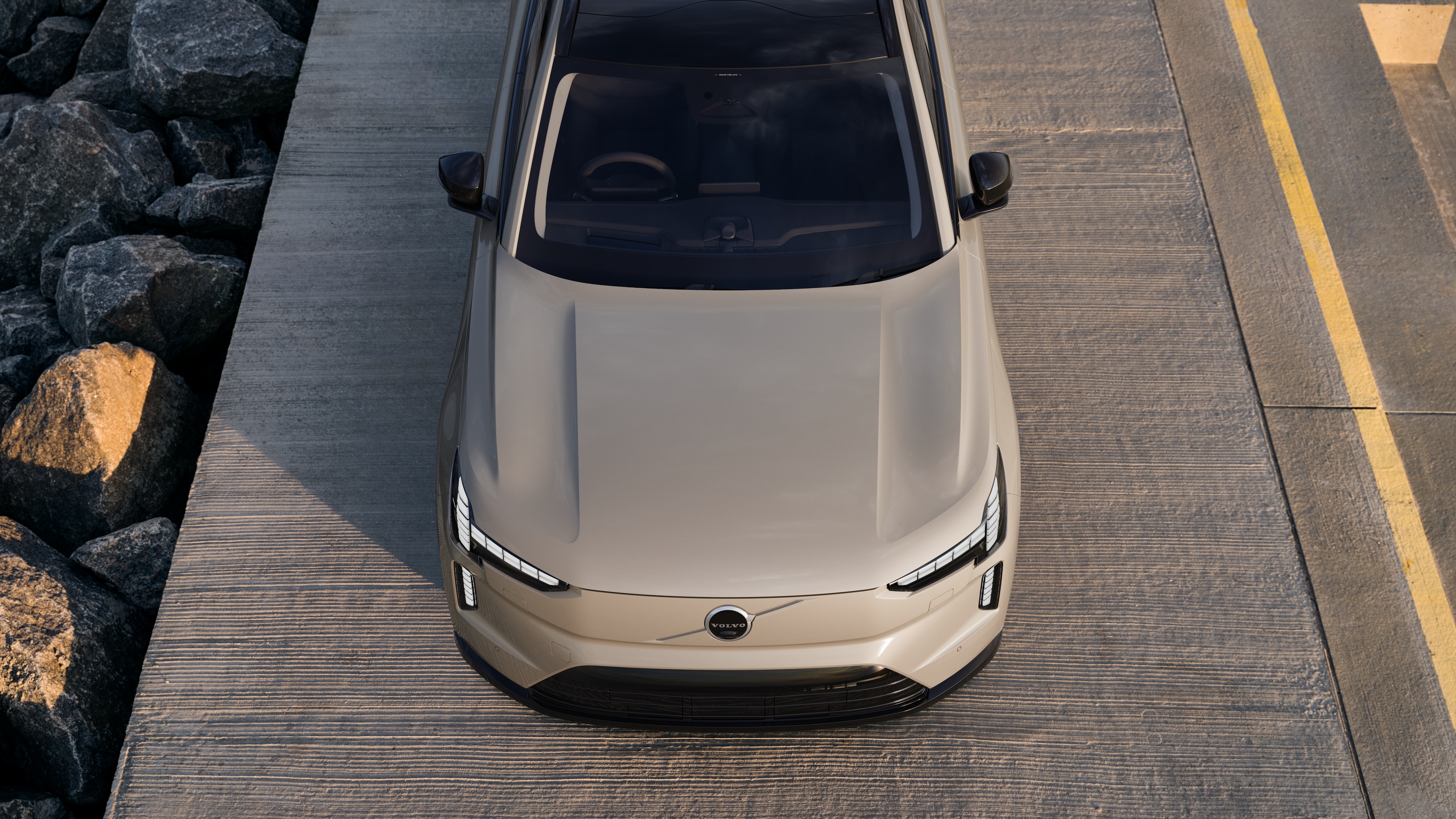 Volvo car exterior in three-quarter view on an urban street background, showing one side, roof, and part of the front.