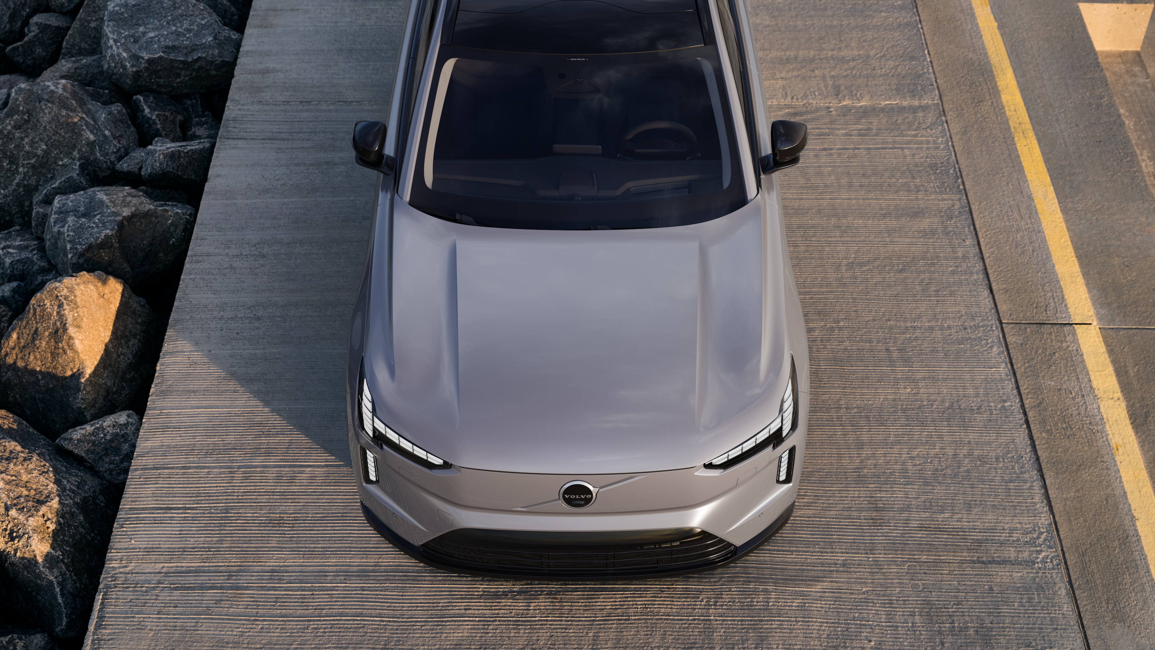 Volvo-auton ulkopuoli kolmen neljäsosan näkymässä kaupunkien katutaustalla, toinen puoli, katto ja osa edestä.