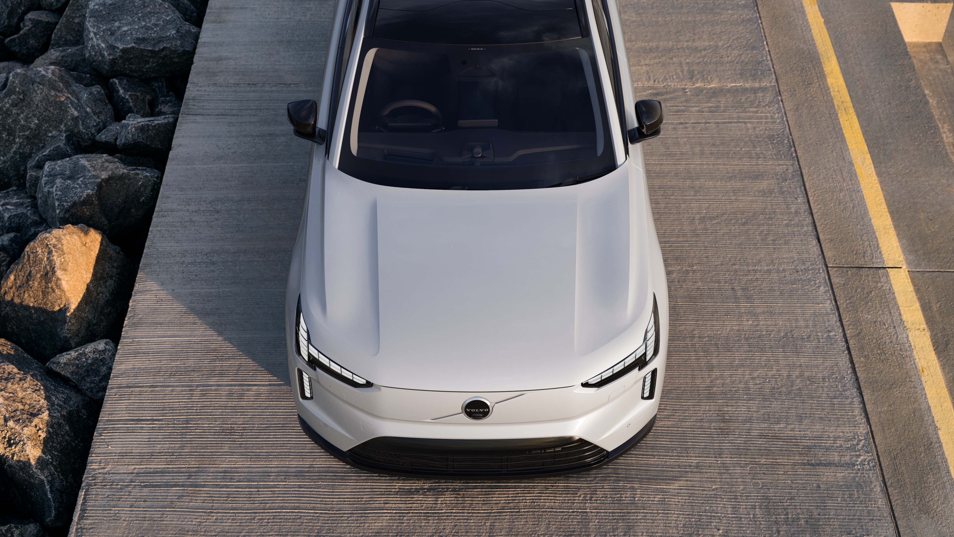 Volvo car exterior in three-quarter view on an urban street background, showing one side, roof, and part of the front.