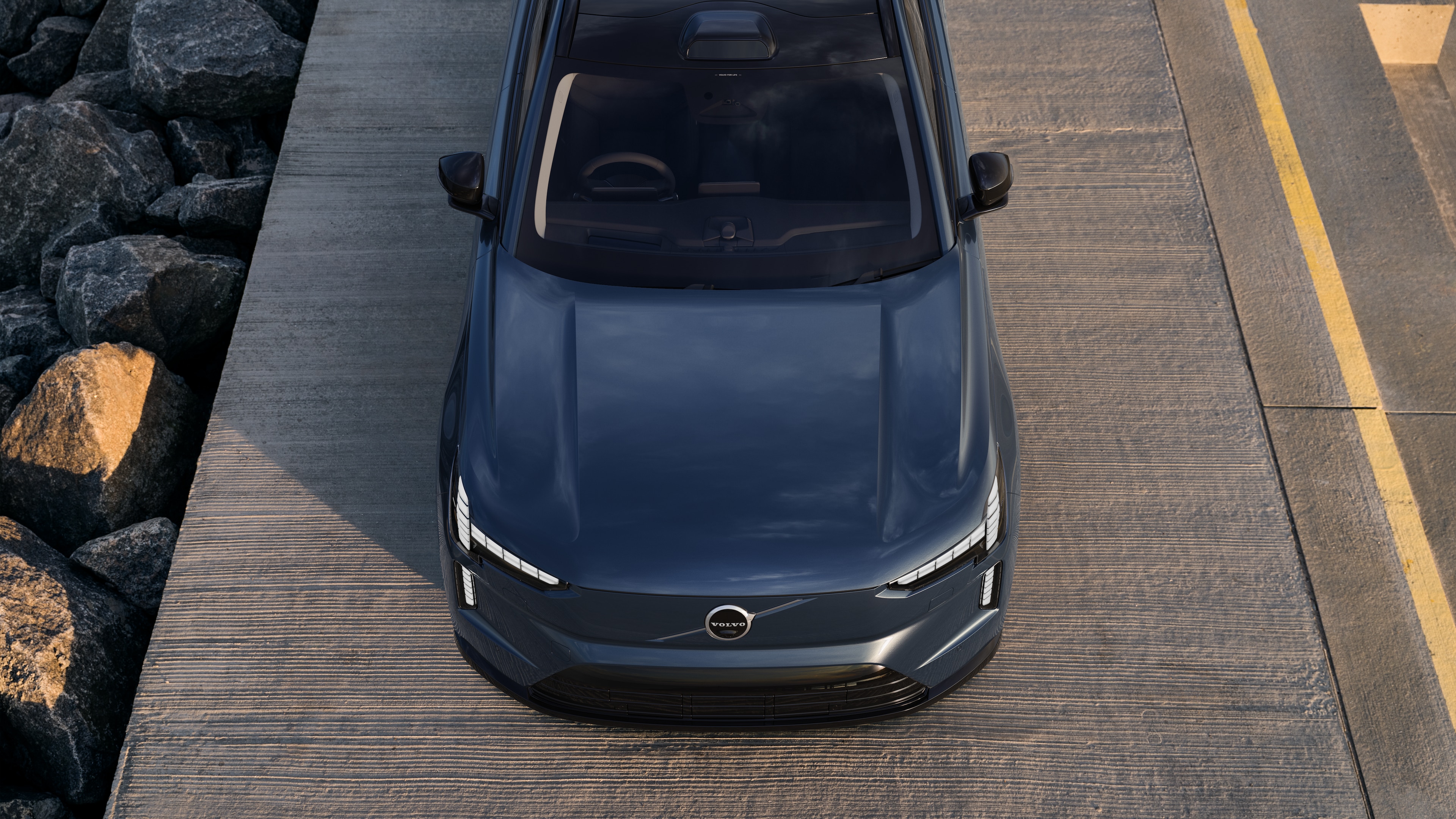 Volvo car exterior in three-quarter view on an urban street background, showing one side, roof, and part of the front.