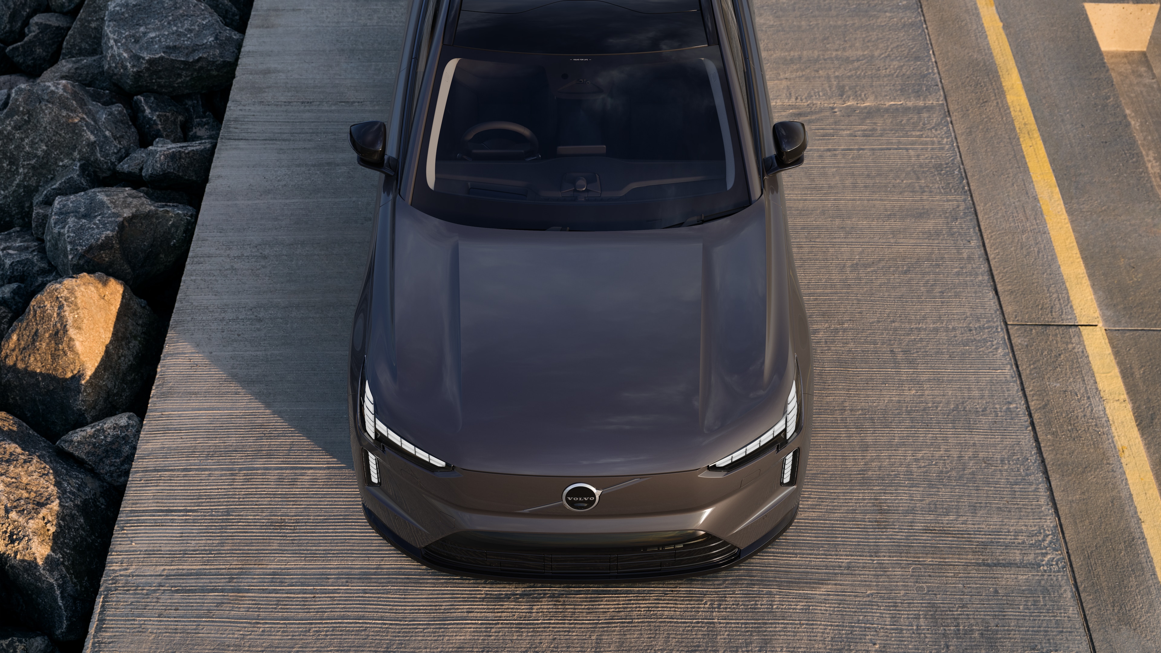 Volvo car exterior in three-quarter view on an urban street background, showing one side, roof, and part of the front.