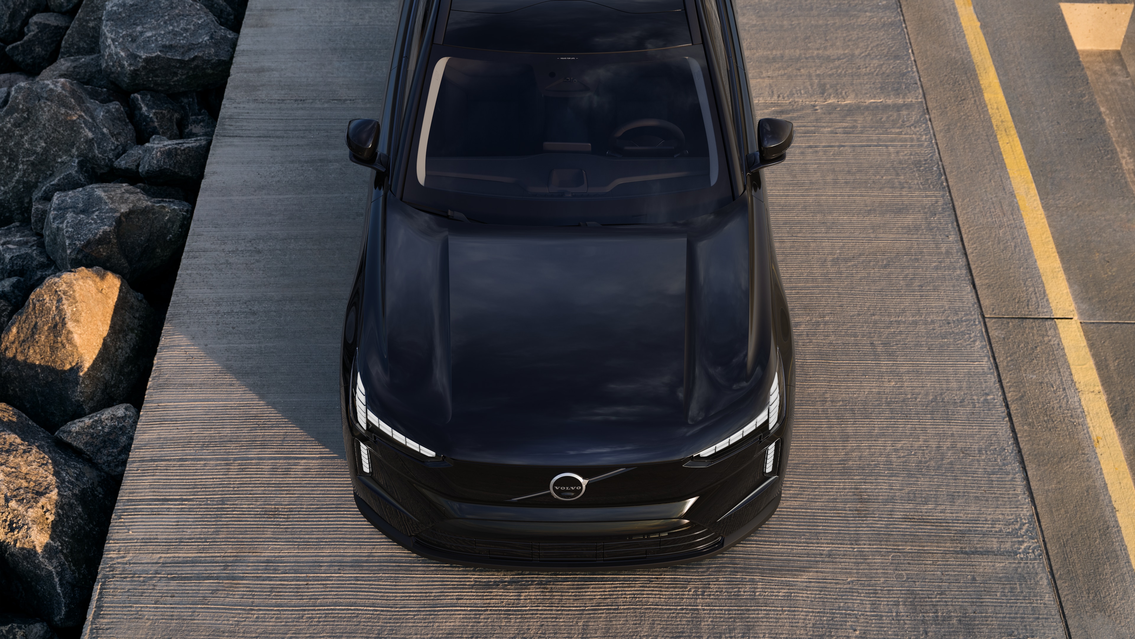 Exterieur van een Volvo in driekwart aanzicht van een stedelijke straatachtergrond, met één kant, dak en een deel van de voorkant.