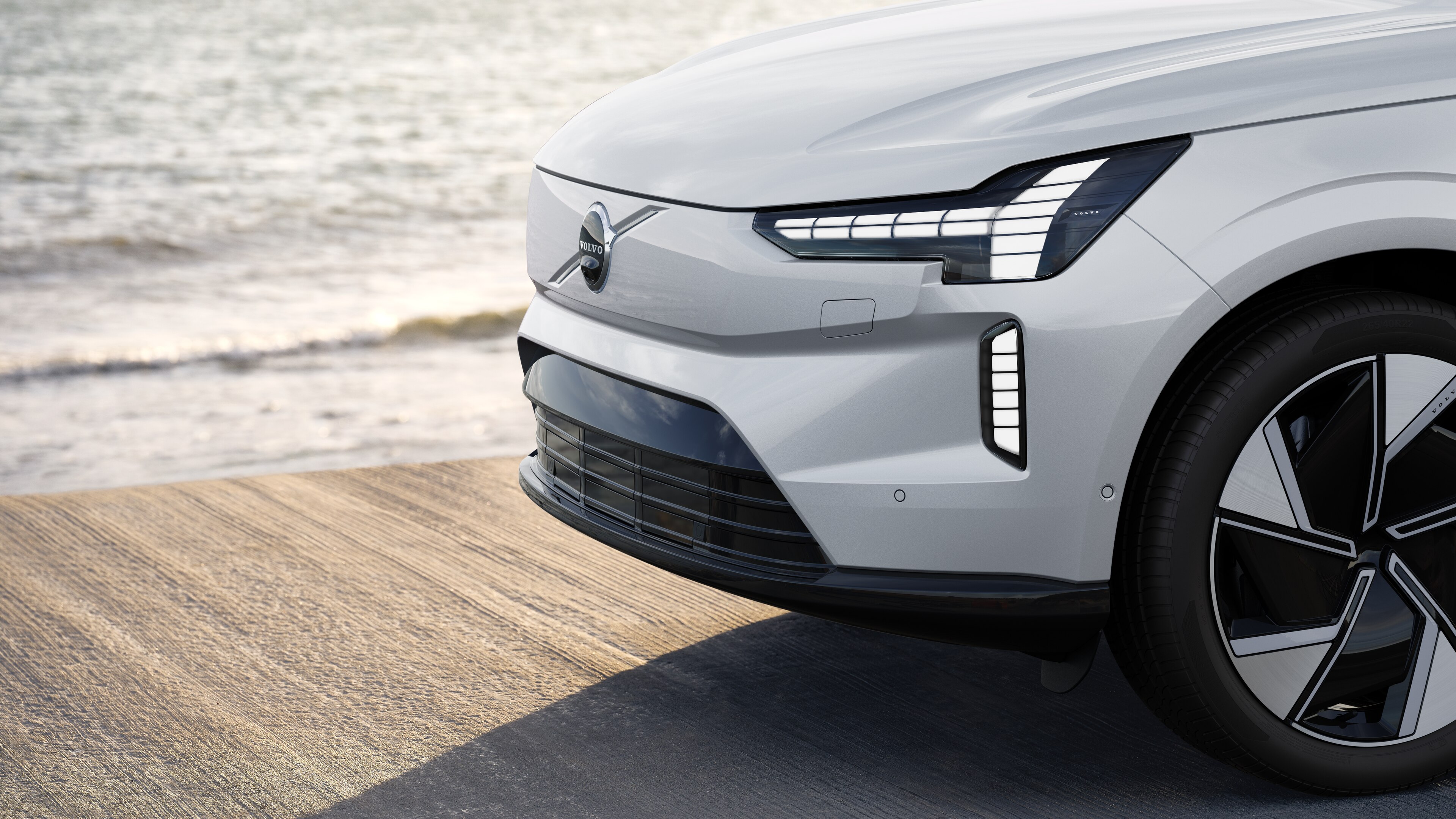 Volvobilens exteriör i trekvartsvy mot en industriell betongväggsbakgrund.