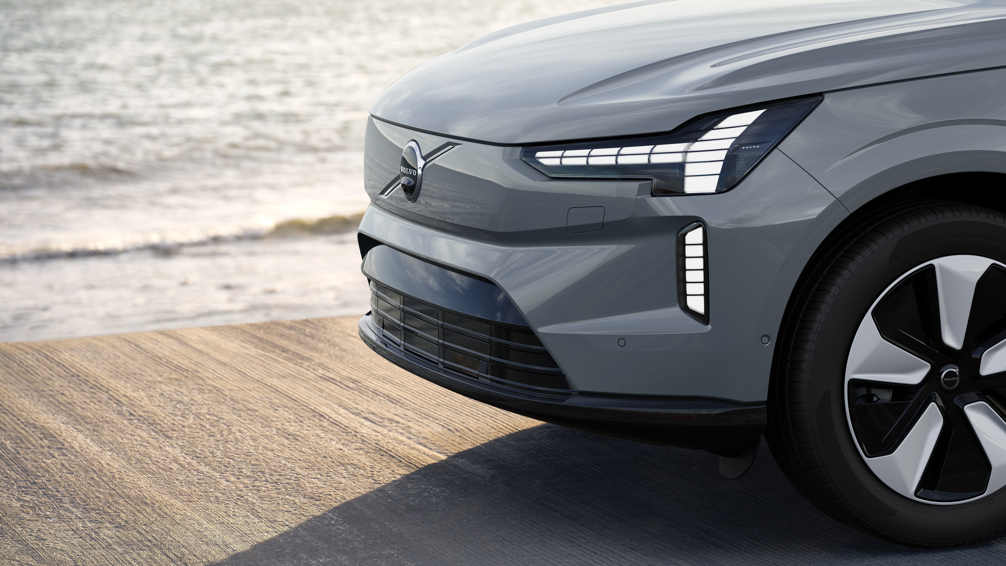 Volvobilens exteriör i trekvartsvy mot en industriell betongväggsbakgrund.