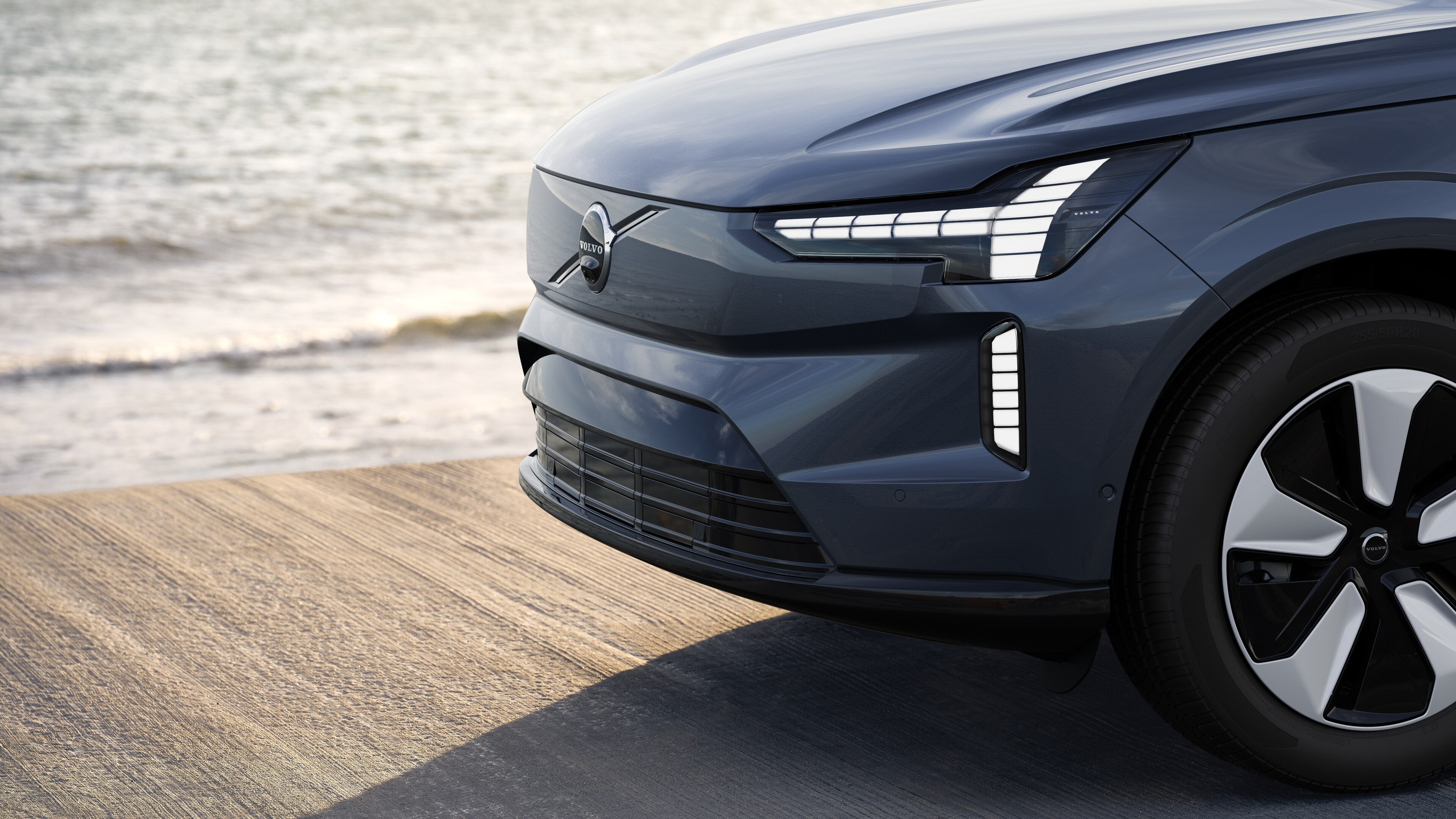 Esterno di un'auto Volvo vista di tre quarti sullo sfondo di un muro di cemento industriale.