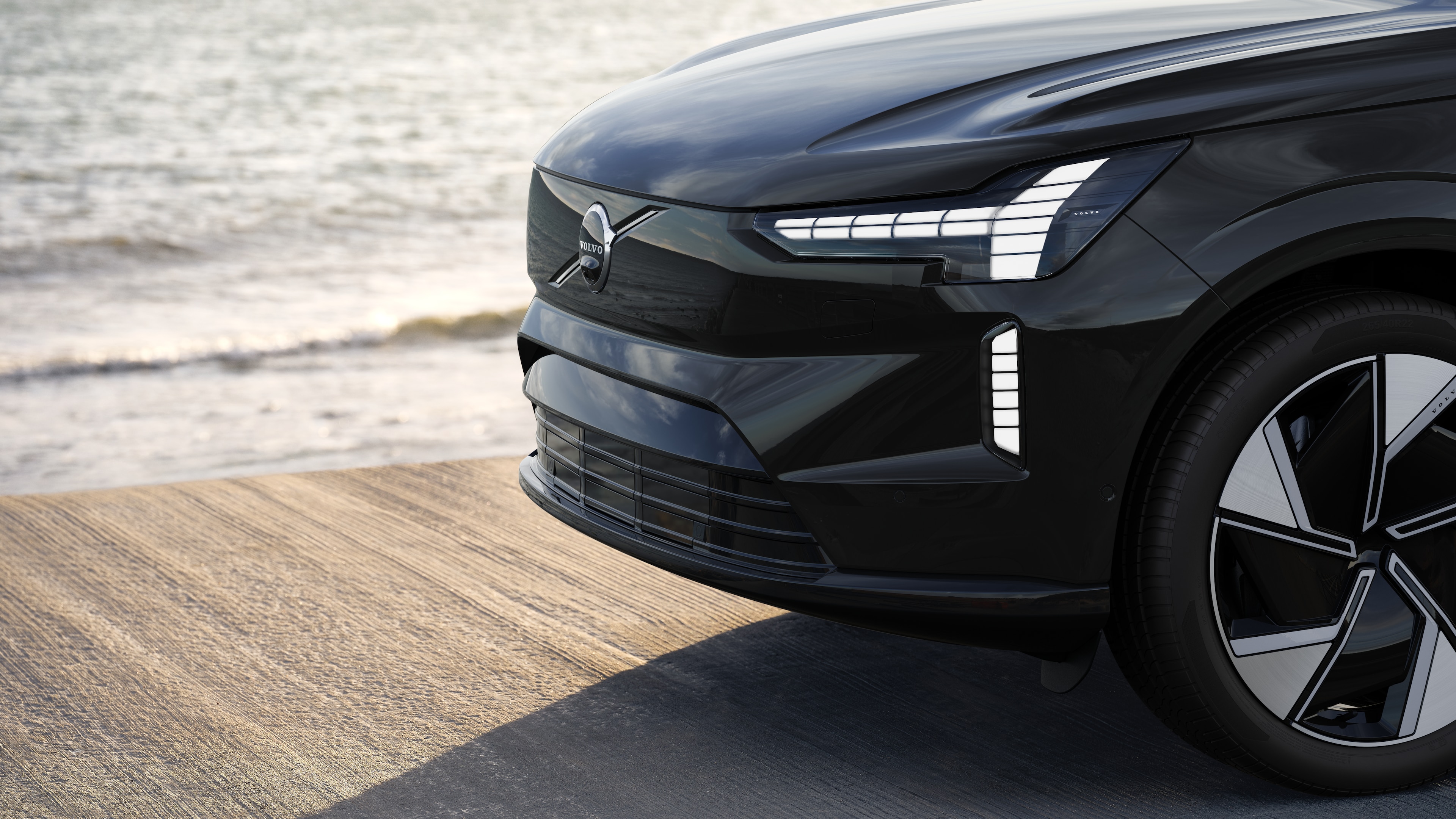 De buitenkant van een Volvo-auto in driekwartaanzicht tegen een achtergrond van een industriële betonnen muur.