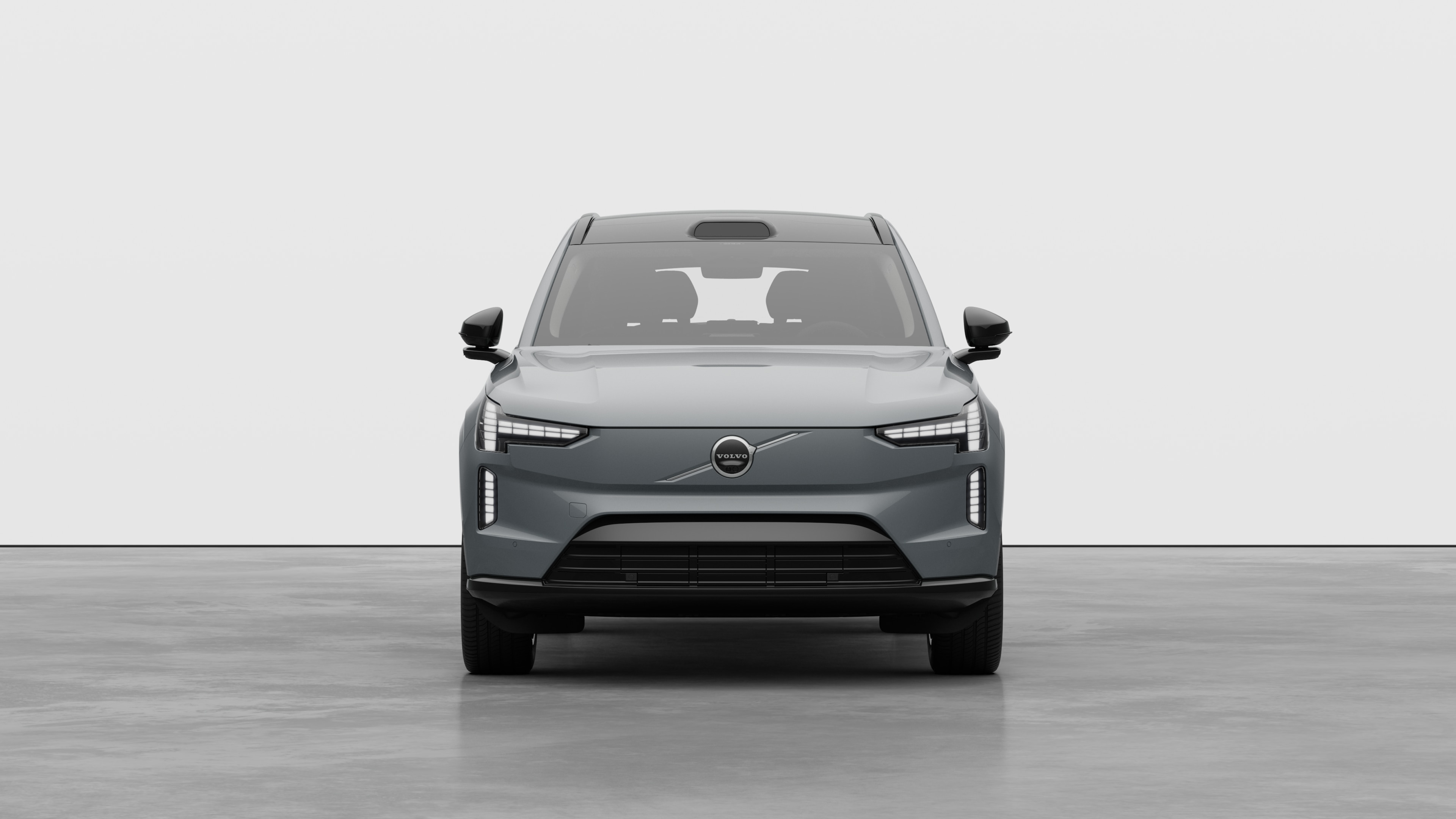 Egy Volvo autó elölnézete egyszerű stúdióháttérben.