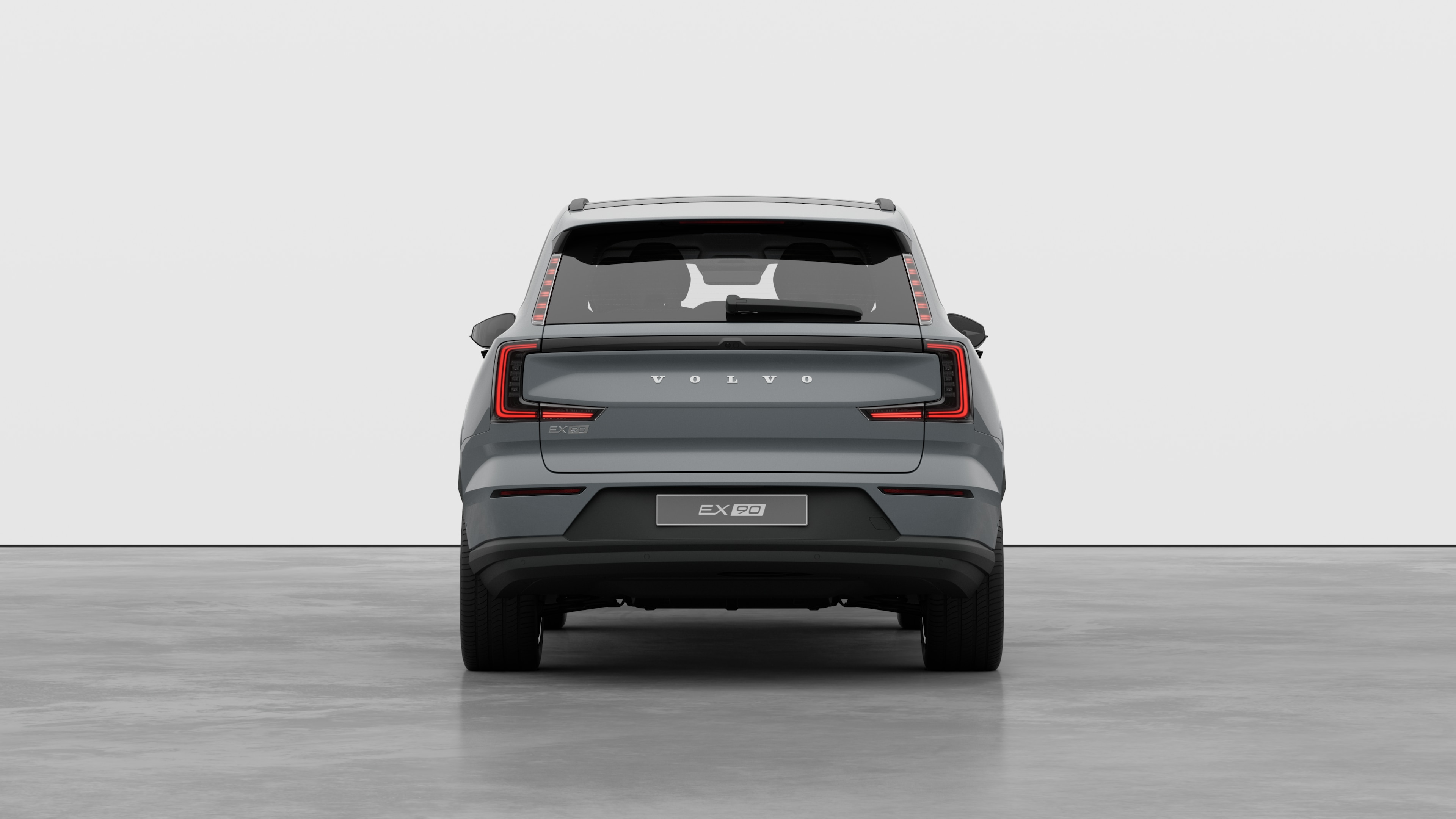 Vue arrière d’une voiture Volvo sur un fond de studio uni.