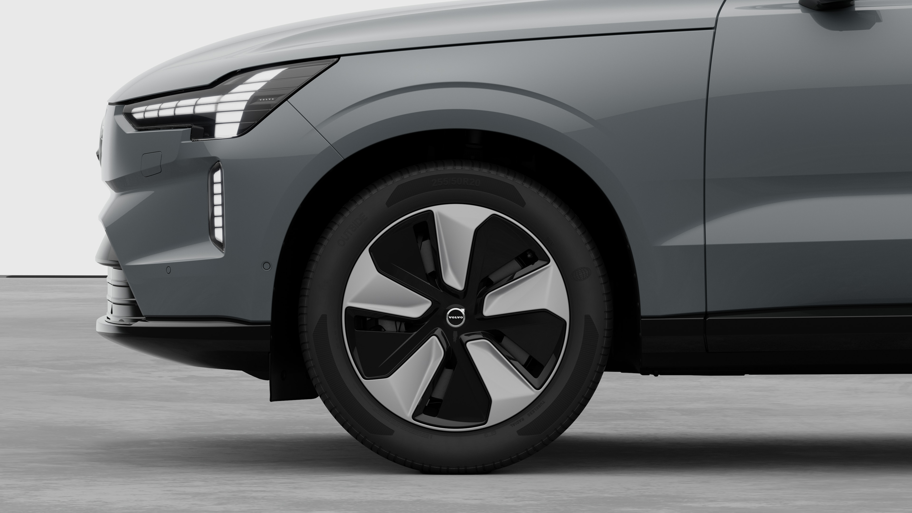 Volvo-bilens udvendige sidebillede med fokus på forhjulet og skærmen, sat op mod en almindelig studiebaggrund.