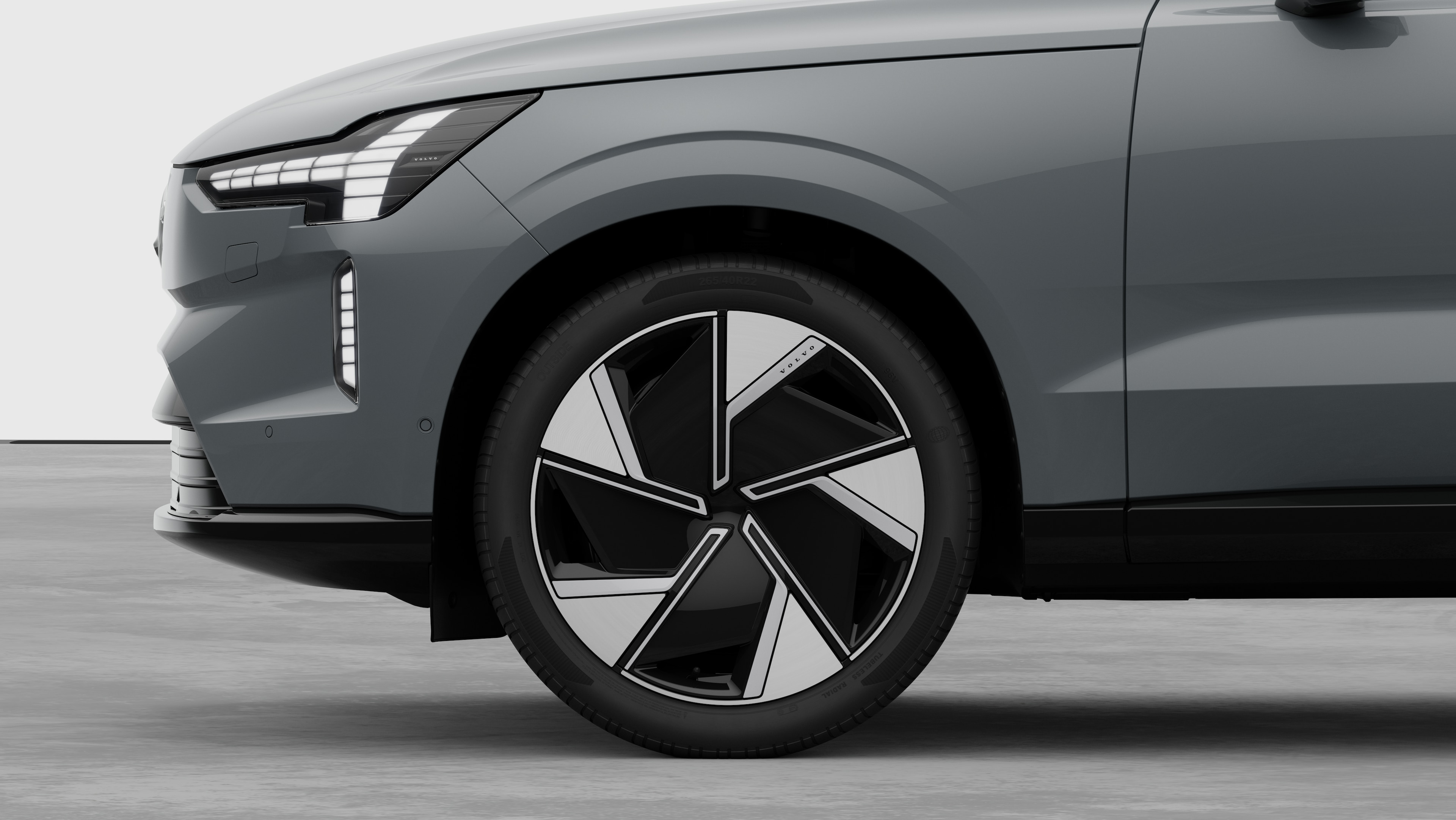 Volvo car exterior side view focusing on the front wheel and fender, set against a plain studio background.