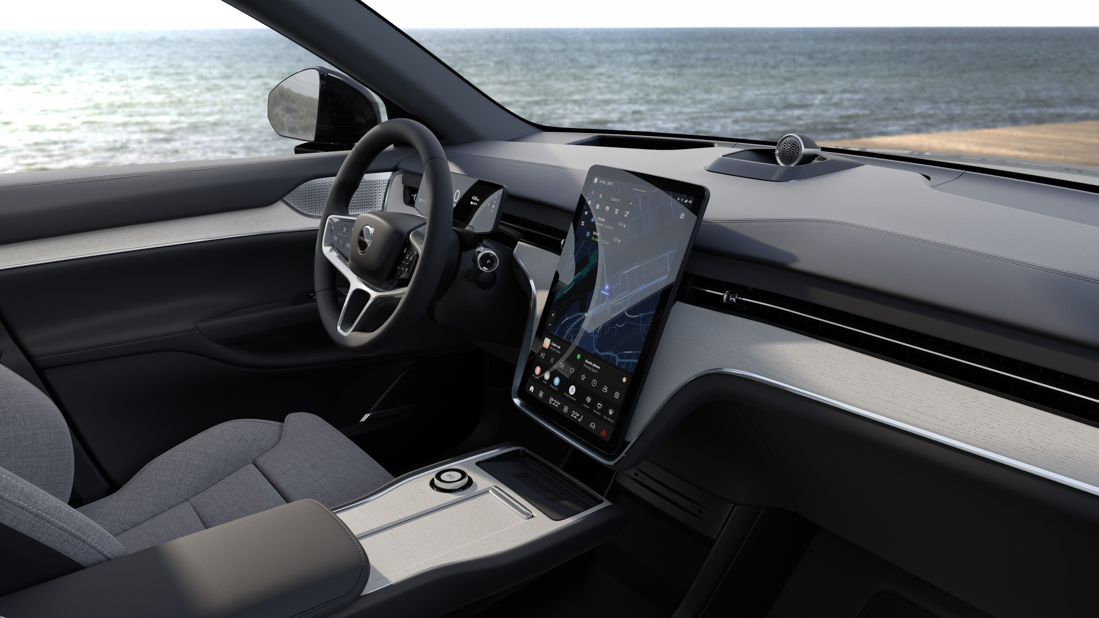 Volvo-interieur met dashboard, stuur en middenconsole met digitaal display op een open wegachtergrond.