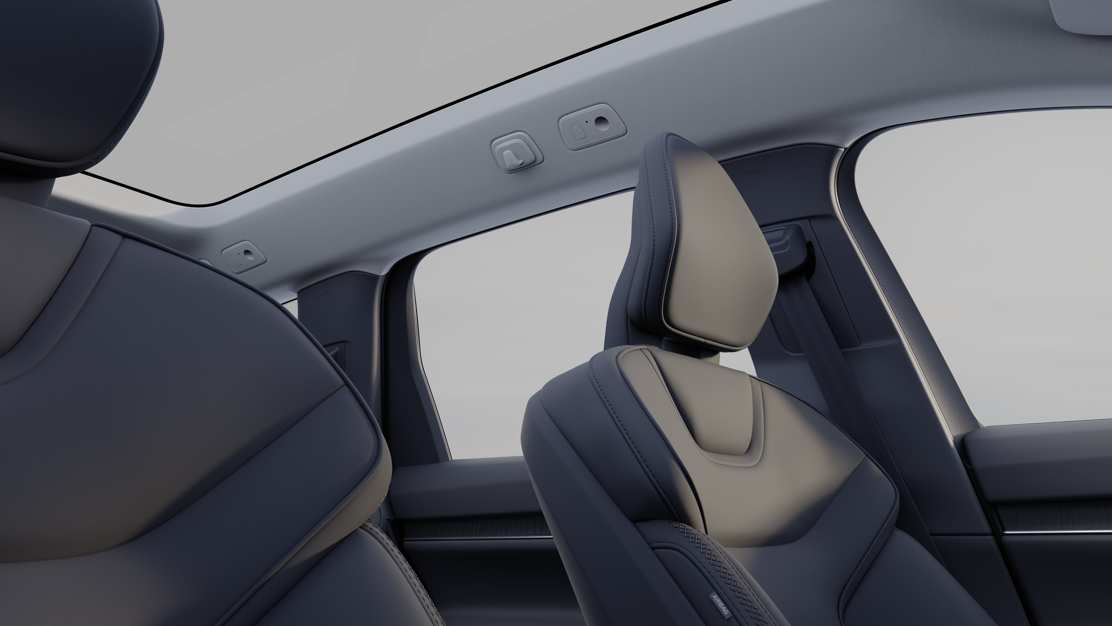 Het interieur van een Volvo met de passagiersstoelen voor- en achterin, het stuur, het dashboard en de middenconsole tegen een effen studioachtergrond.