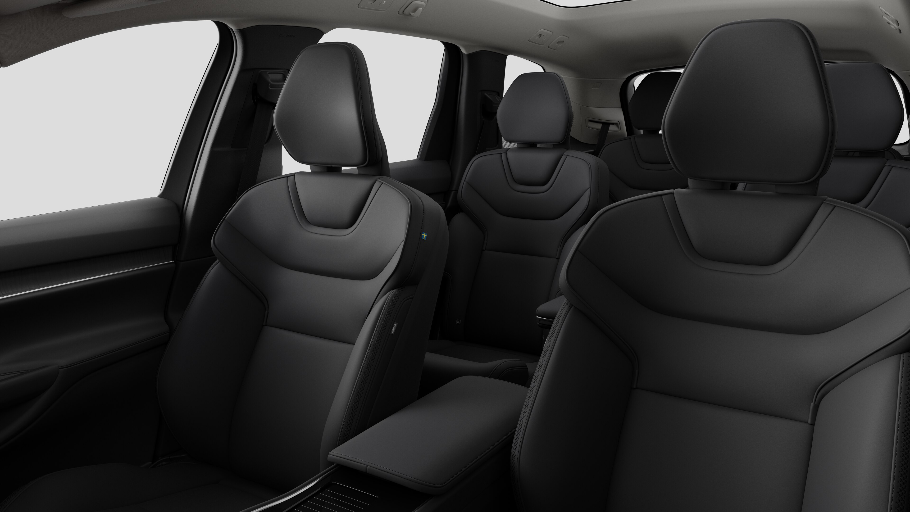 Interieur van de Volvo met de passagiersstoelen achteraan en de middenconsole op een effen studioachtergrond.