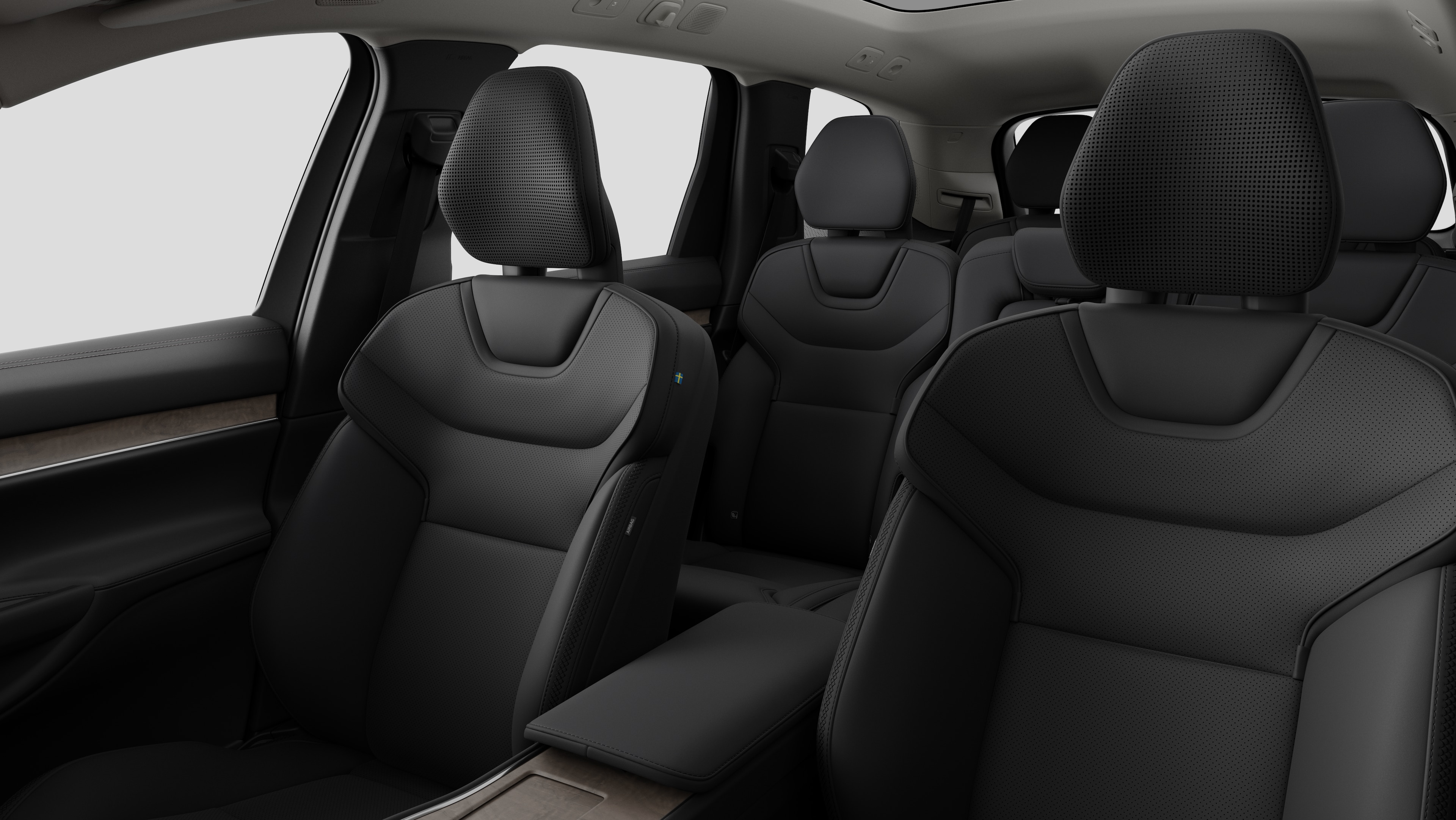 Volvointeriör som visar bakre passagerarsäten och mittkonsol i en vanlig studiobakgrund.