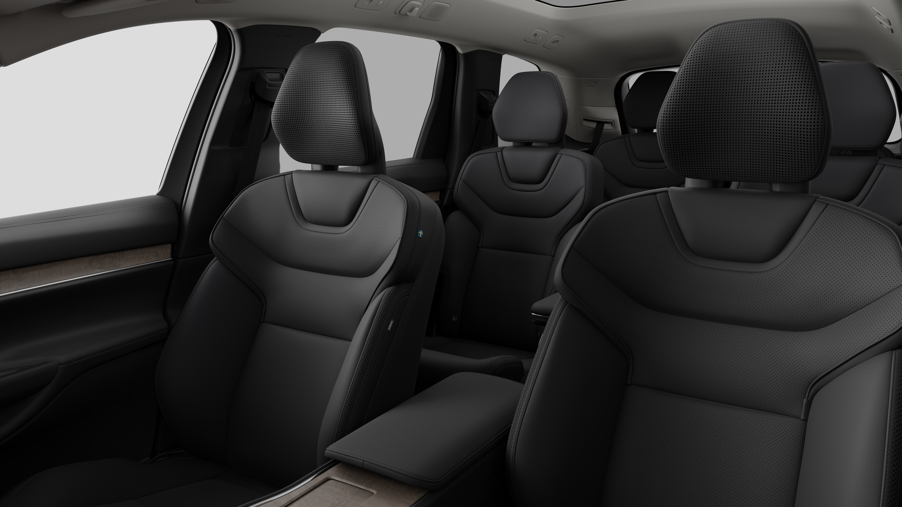 Het interieur van een Volvo met de passagiersstoelen achterin en de middenconsole in een effen studioachtergrond.
