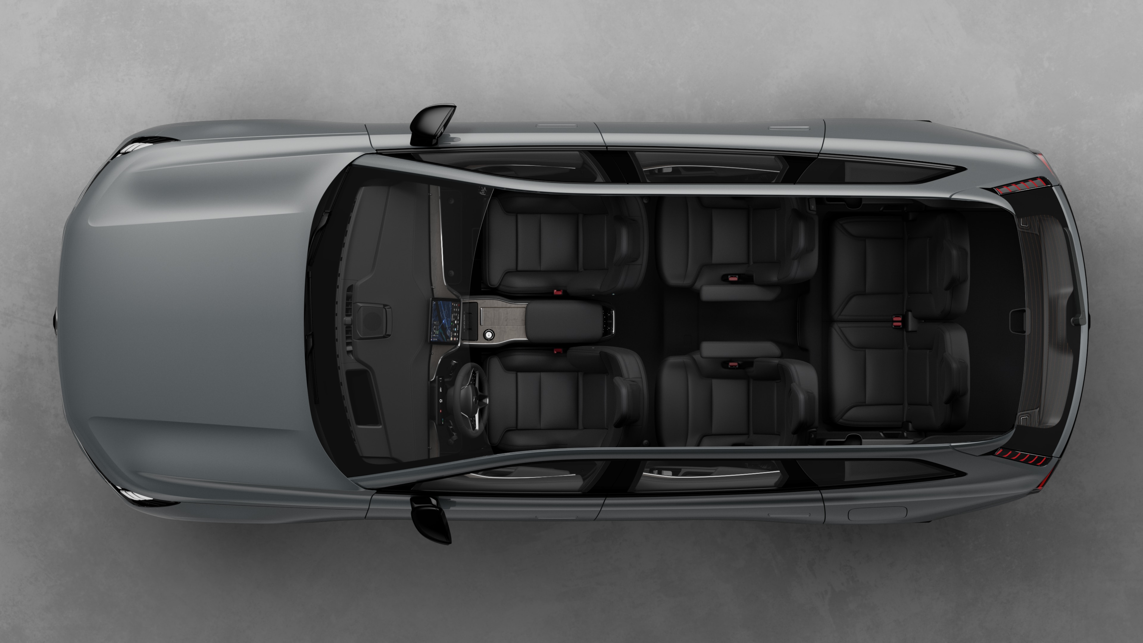 Vy ovanifrån av Volvobilens interiör med två sätesrader, instrumentbräda och mittkonsol mot en vanlig studiobakgrund.