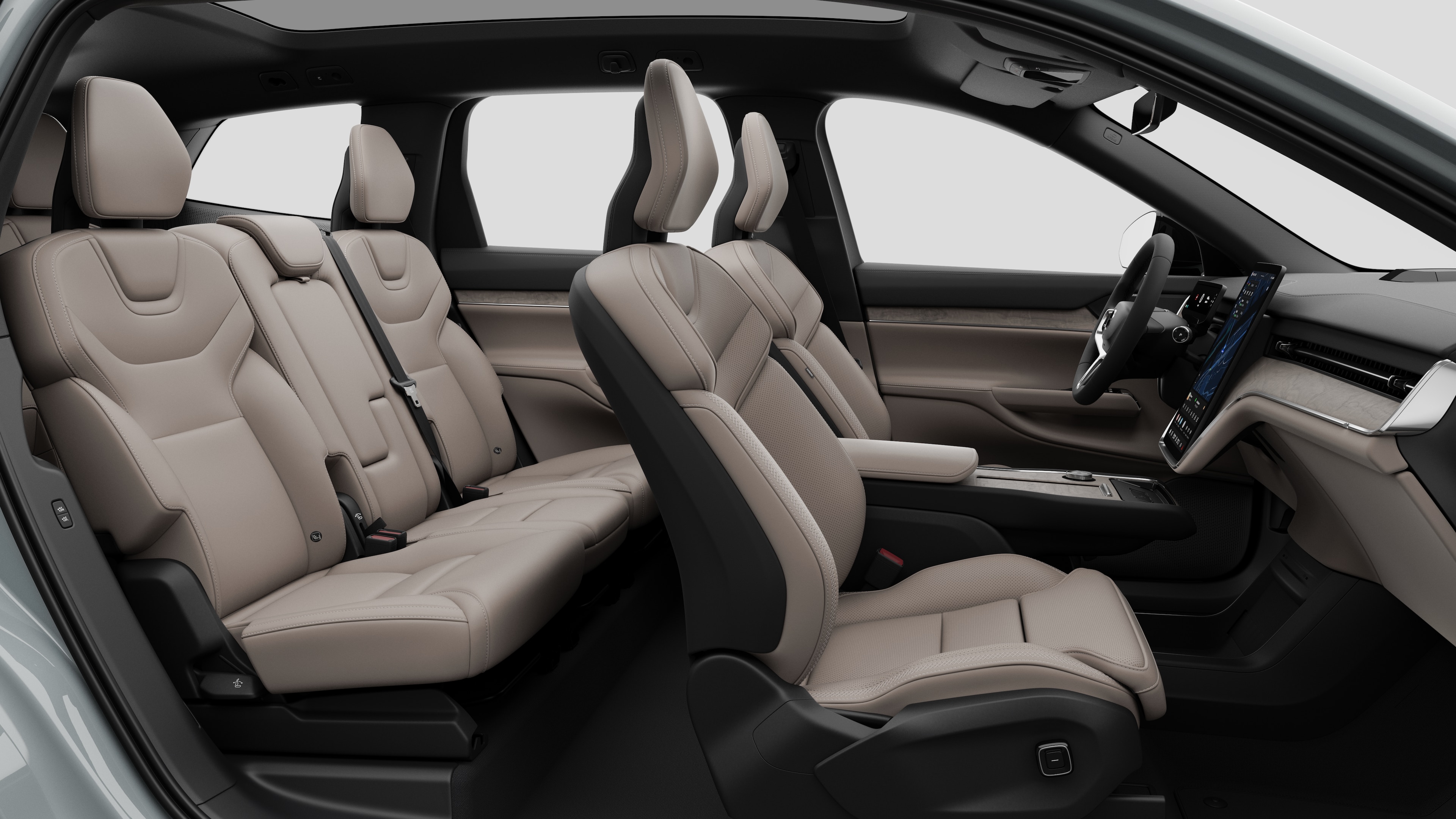 Vista laterale interna di un'auto Volvo che mostra i sedili anteriori, i sedili posteriori, il volante, il cruscotto e la console centrale, sullo sfondo di uno studio semplice.