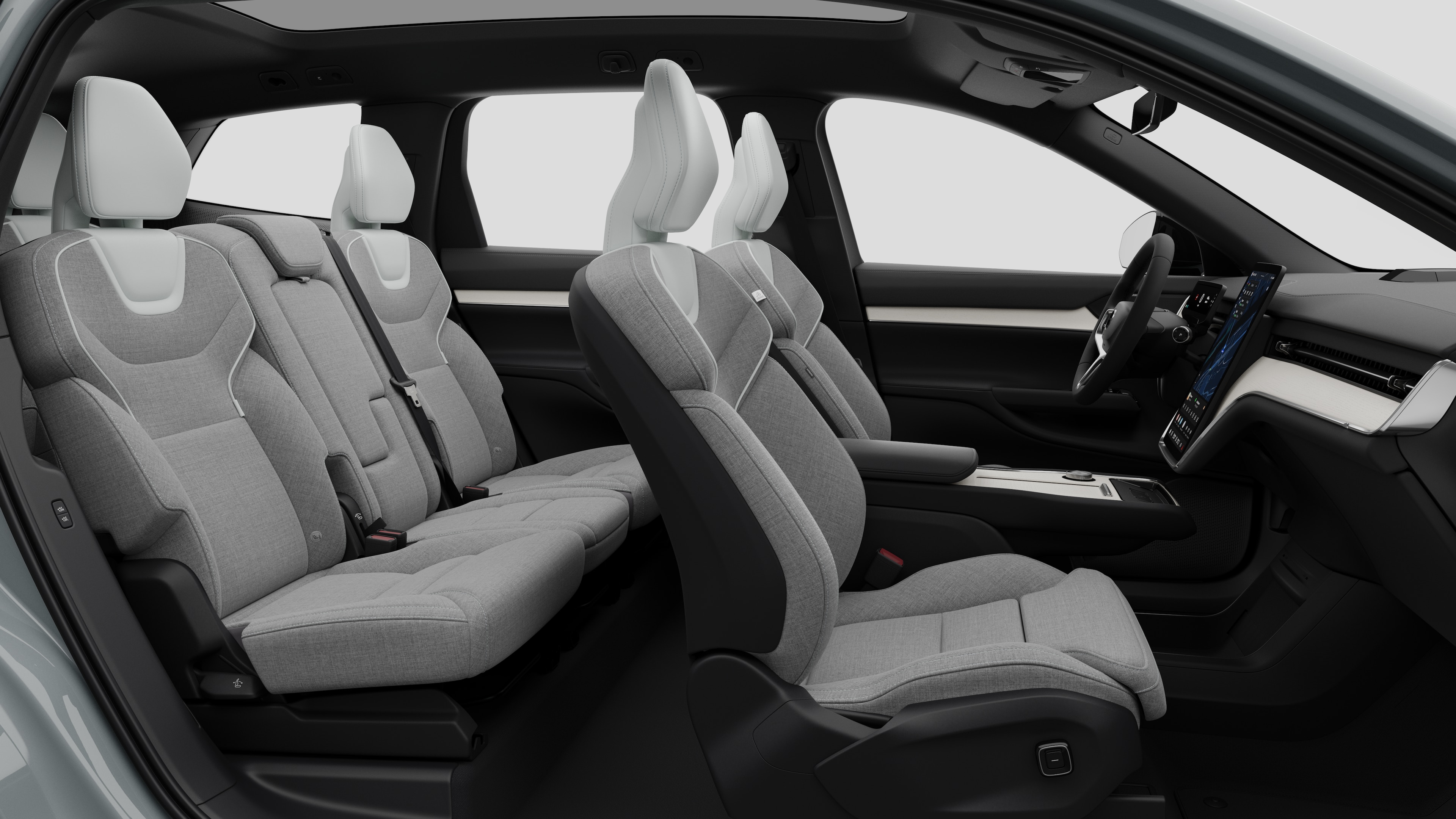 Vista laterale interna di un'auto Volvo che mostra i sedili anteriori, i sedili posteriori, il volante, il cruscotto e la console centrale, sullo sfondo di uno studio semplice.