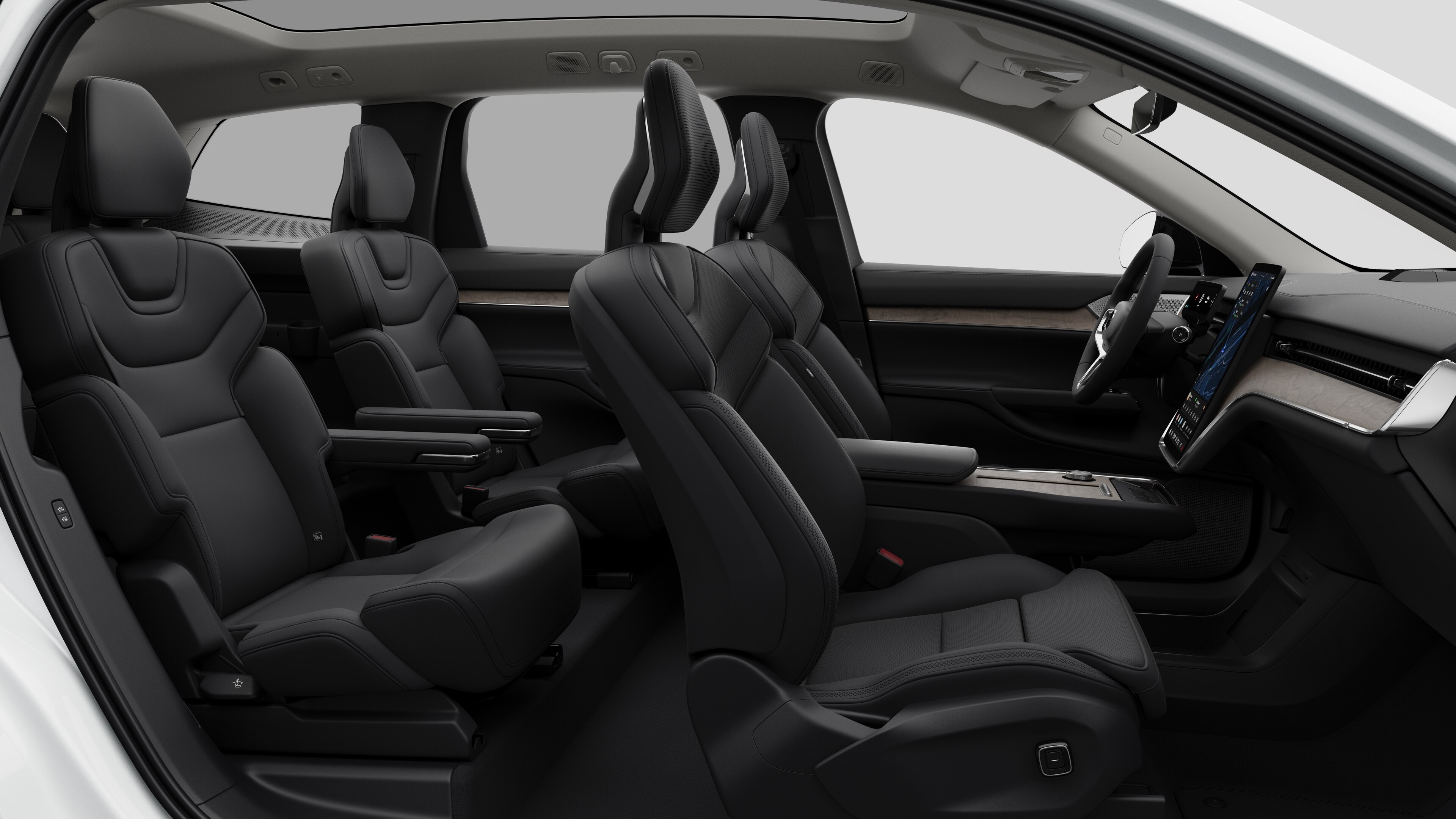 Zijaanzicht van het interieur van een Volvo met de voorstoelen, de passagiersstoelen achterin, het stuur, het dashboard en de middenconsole, tegen een effen studioachtergrond.
