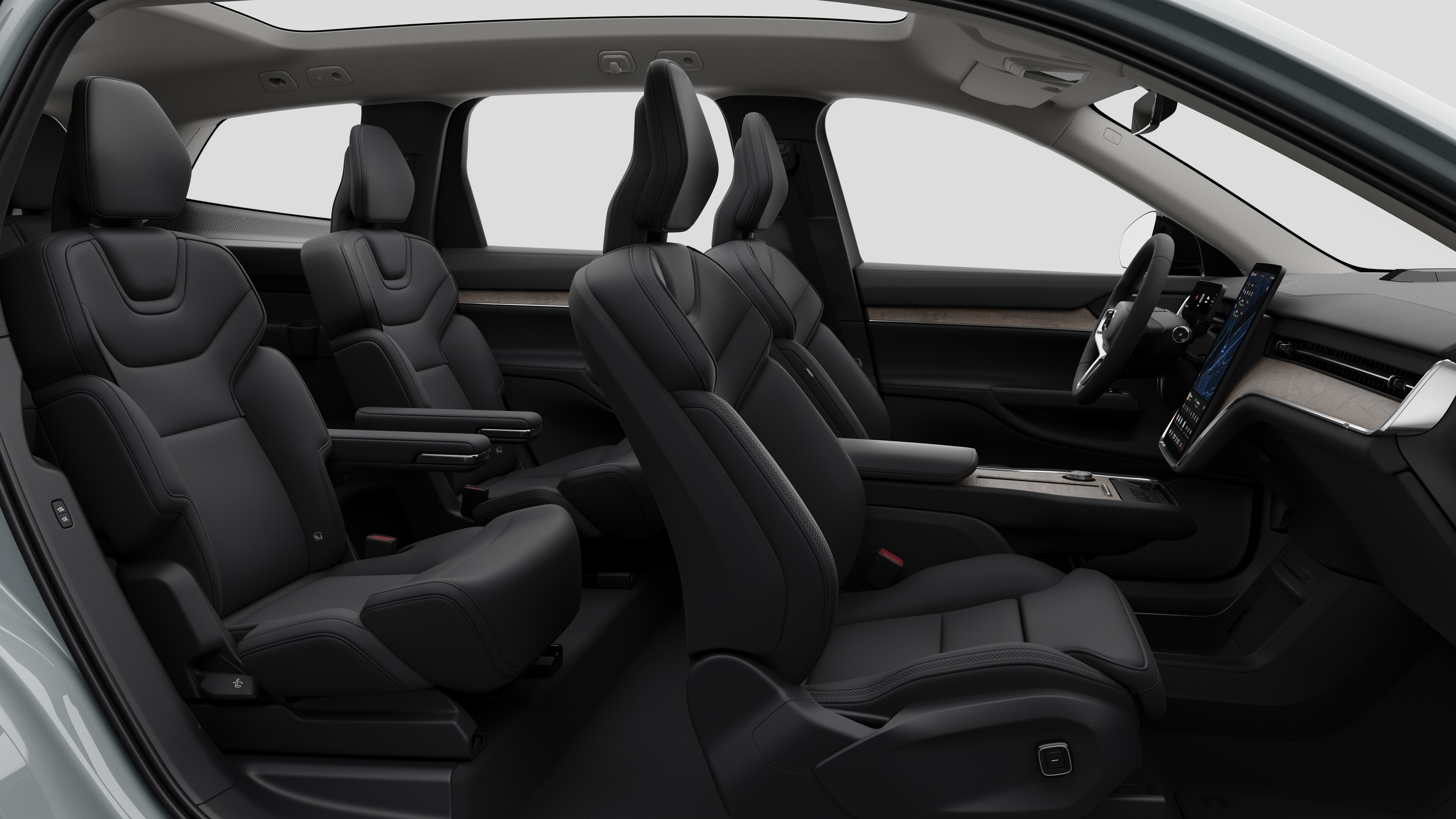 Vue latérale de l’intérieur d’une Volvo montrant les sièges avant, les sièges passager arrière, le volant, le tableau de bord et la console centrale, sur fond de studio.