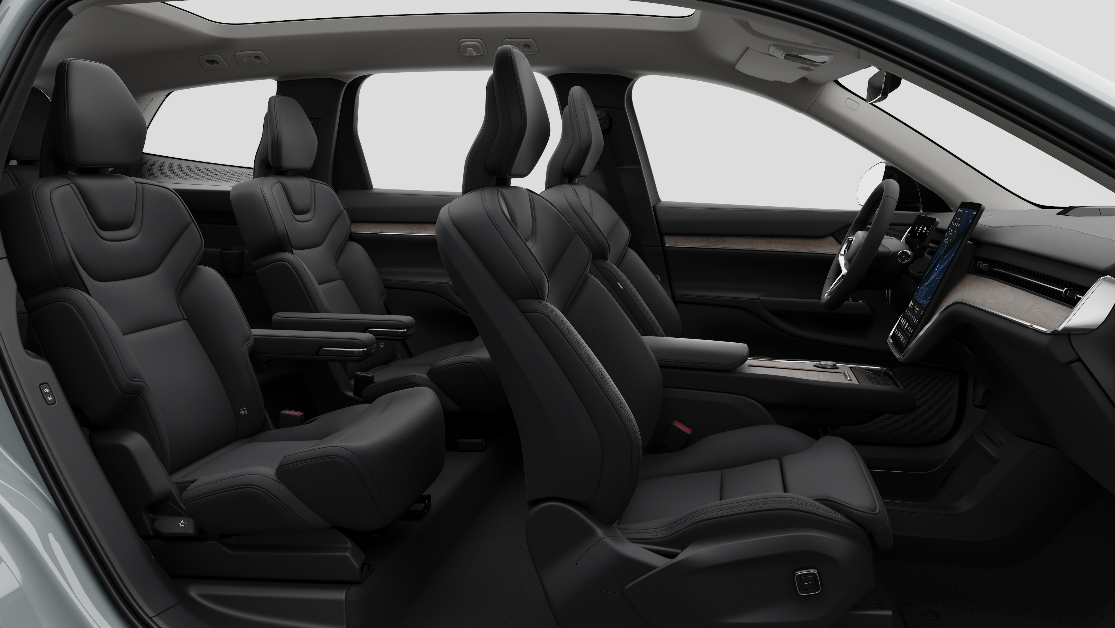 Volvos innvendige sidevisning med forseter, bakseter, ratt, dashbord og midtkonsoll, satt mot vanlig studiobakgrunn.