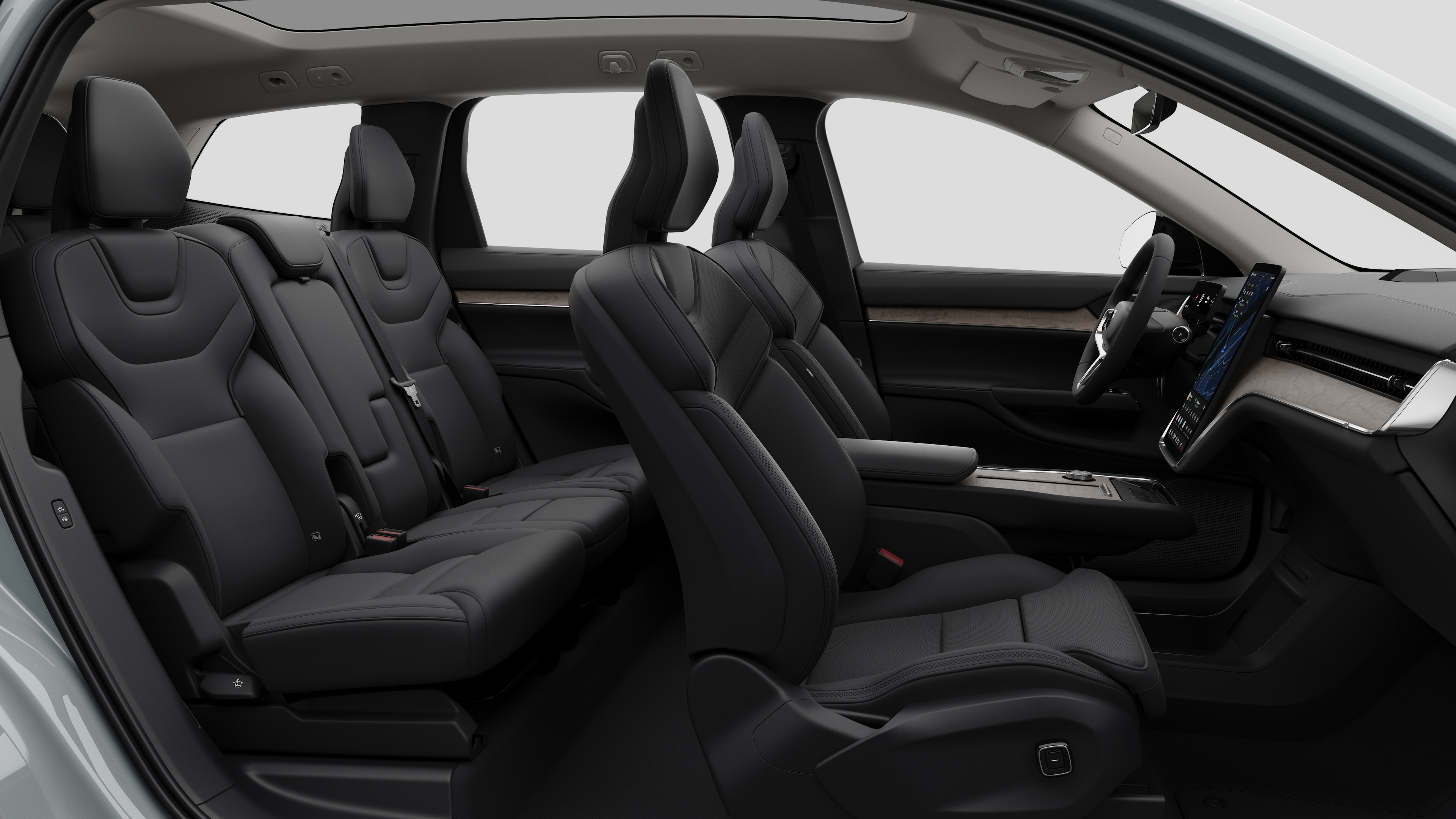 Vista laterale interna di un'auto Volvo che mostra i sedili anteriori, i sedili posteriori, il volante, il cruscotto e la console centrale, sullo sfondo di uno studio semplice.