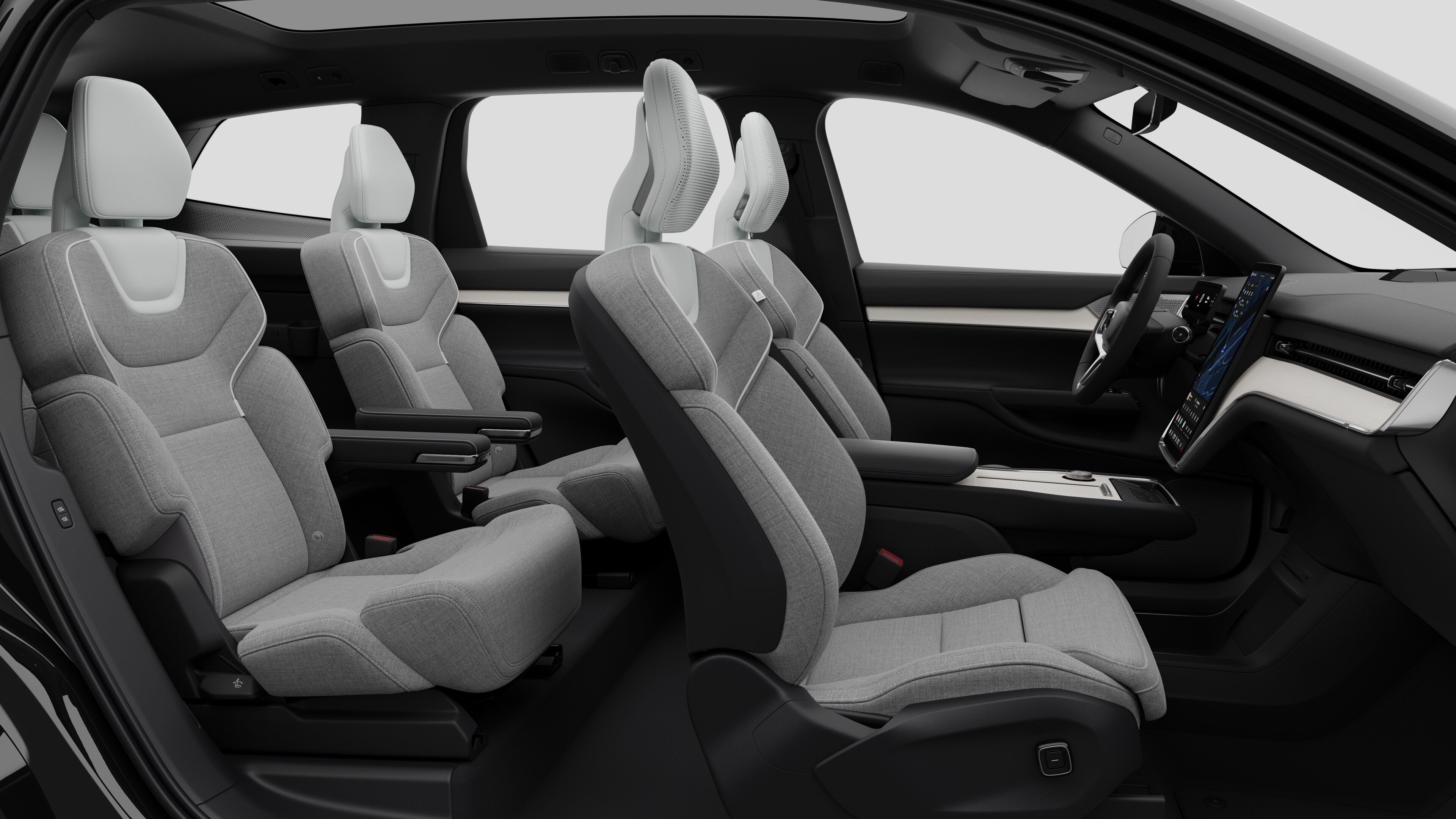 Zijaanzicht van het interieur van een Volvo met de voorstoelen, de passagiersstoelen achterin, het stuur, het dashboard en de middenconsole, tegen een effen studioachtergrond.