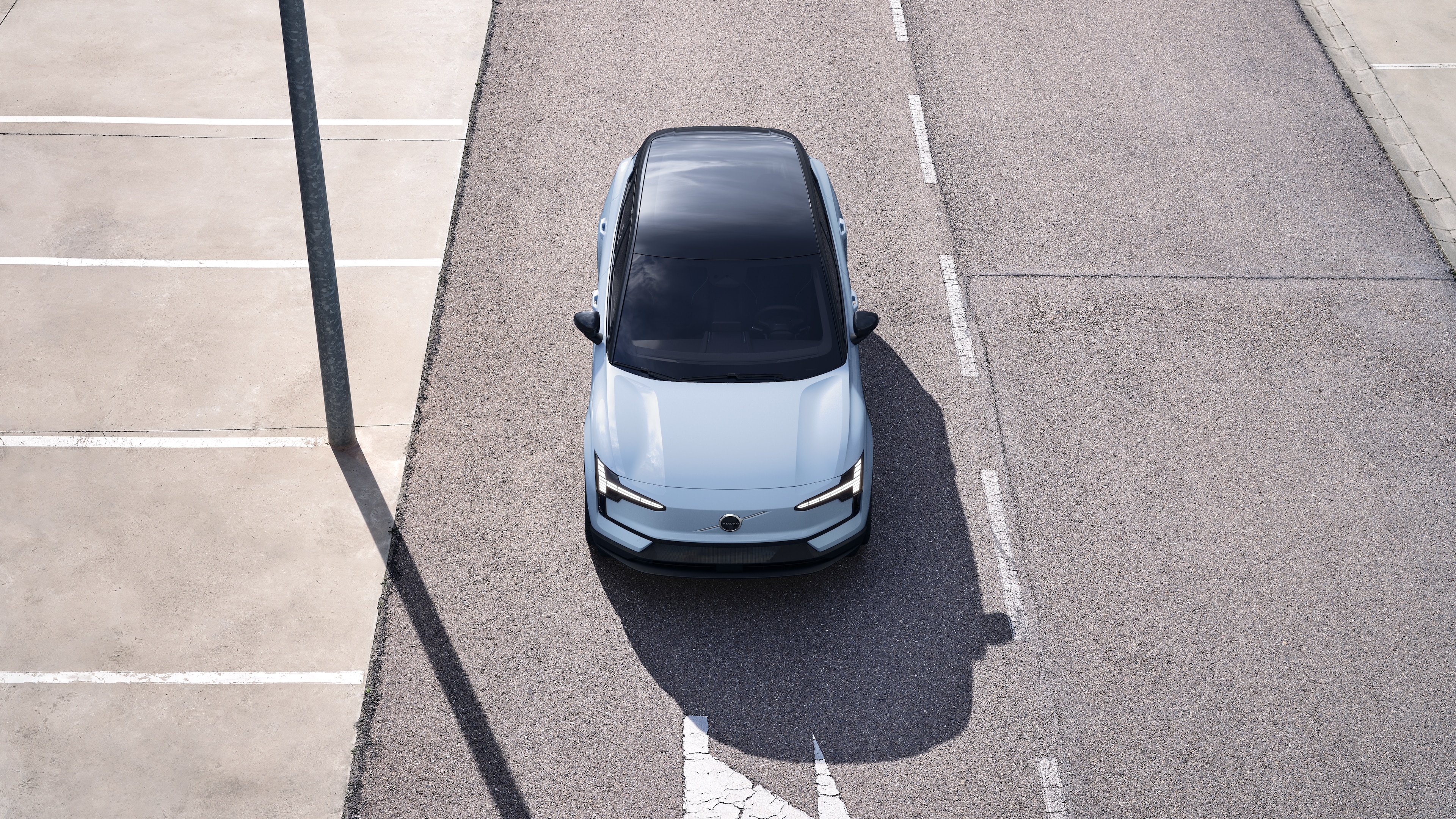 "Volvo" automobilio išorė su trijų ketvirčių vaizdu miesto gatvės fone, parodant vieną pusę, stogą ir dalį priekio.