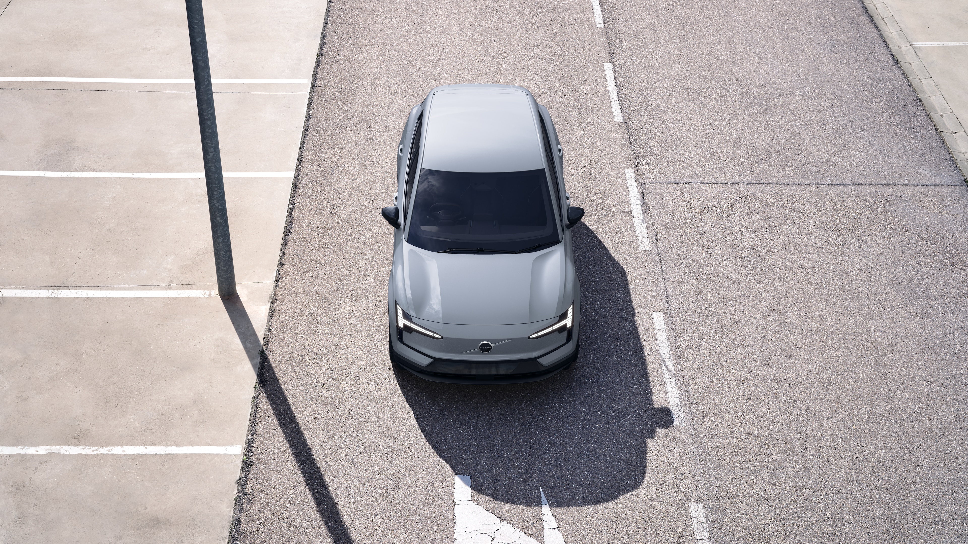 Volvo car exterior in three-quarter view on an urban street background, showing one side, roof, and part of the front.