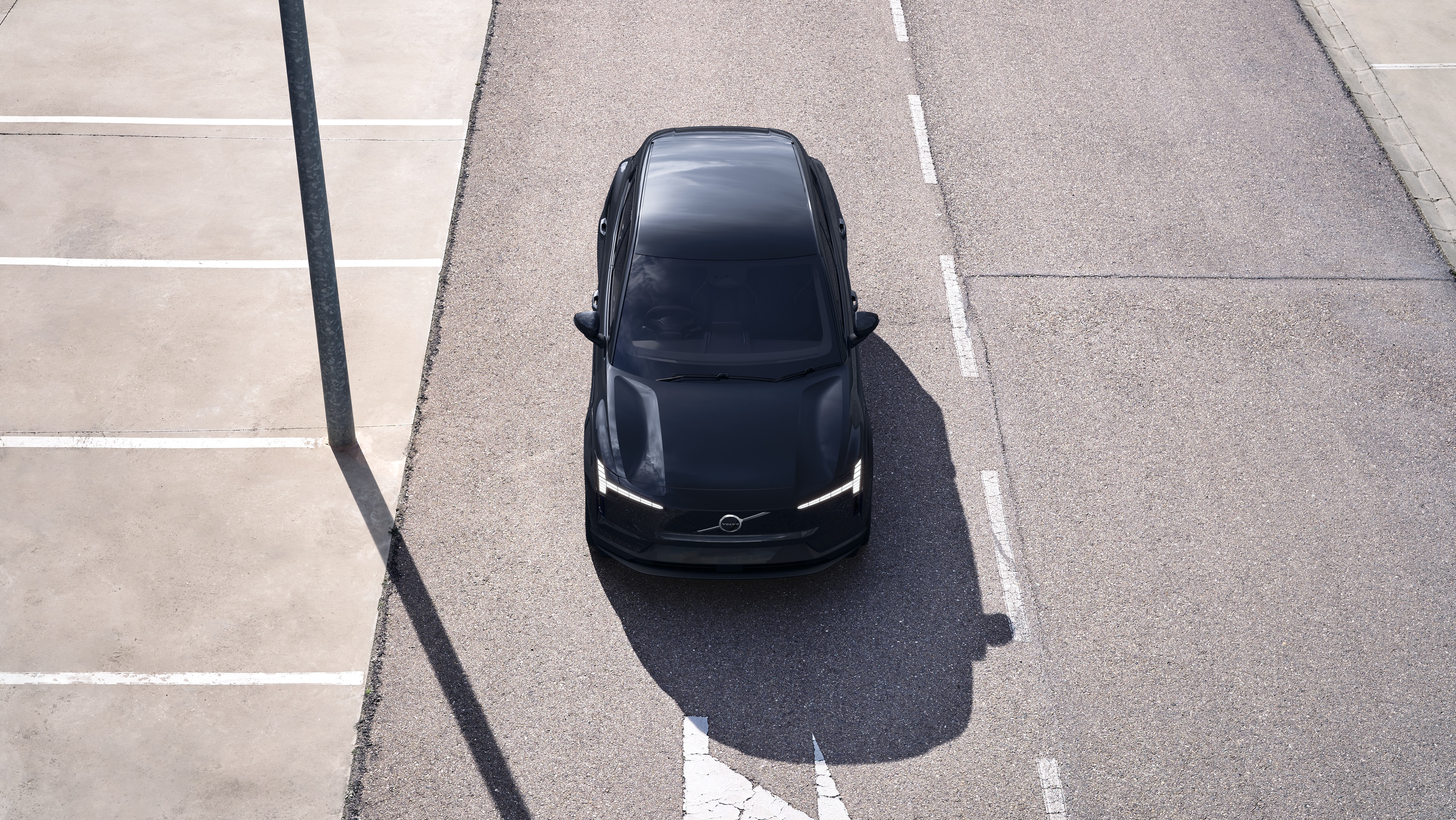 Volvo car exterior in three-quarter view on an urban street background, showing one side, roof, and part of the front.