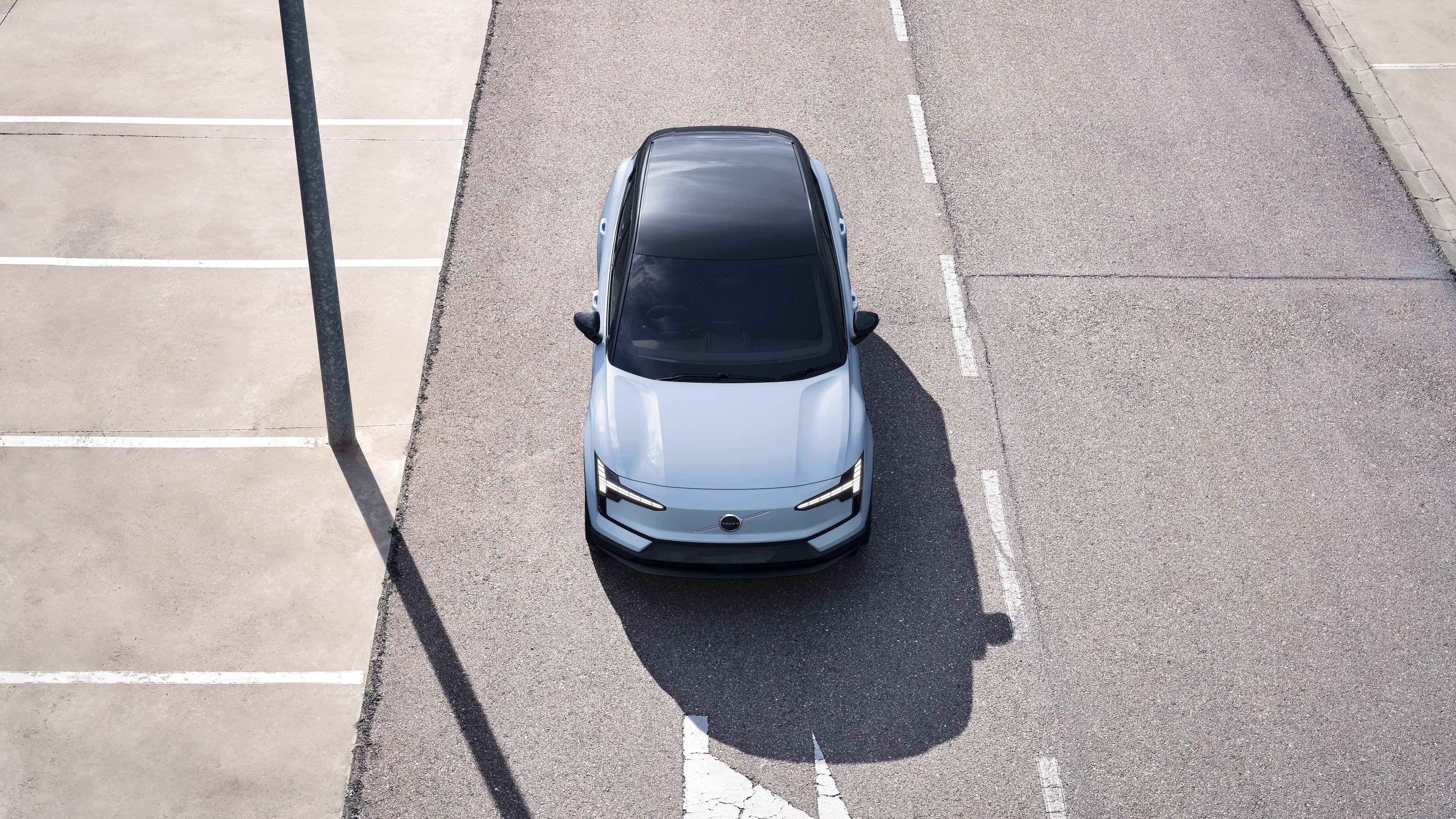 Volvo car exterior in three-quarter view on an urban street background, showing one side, roof, and part of the front.