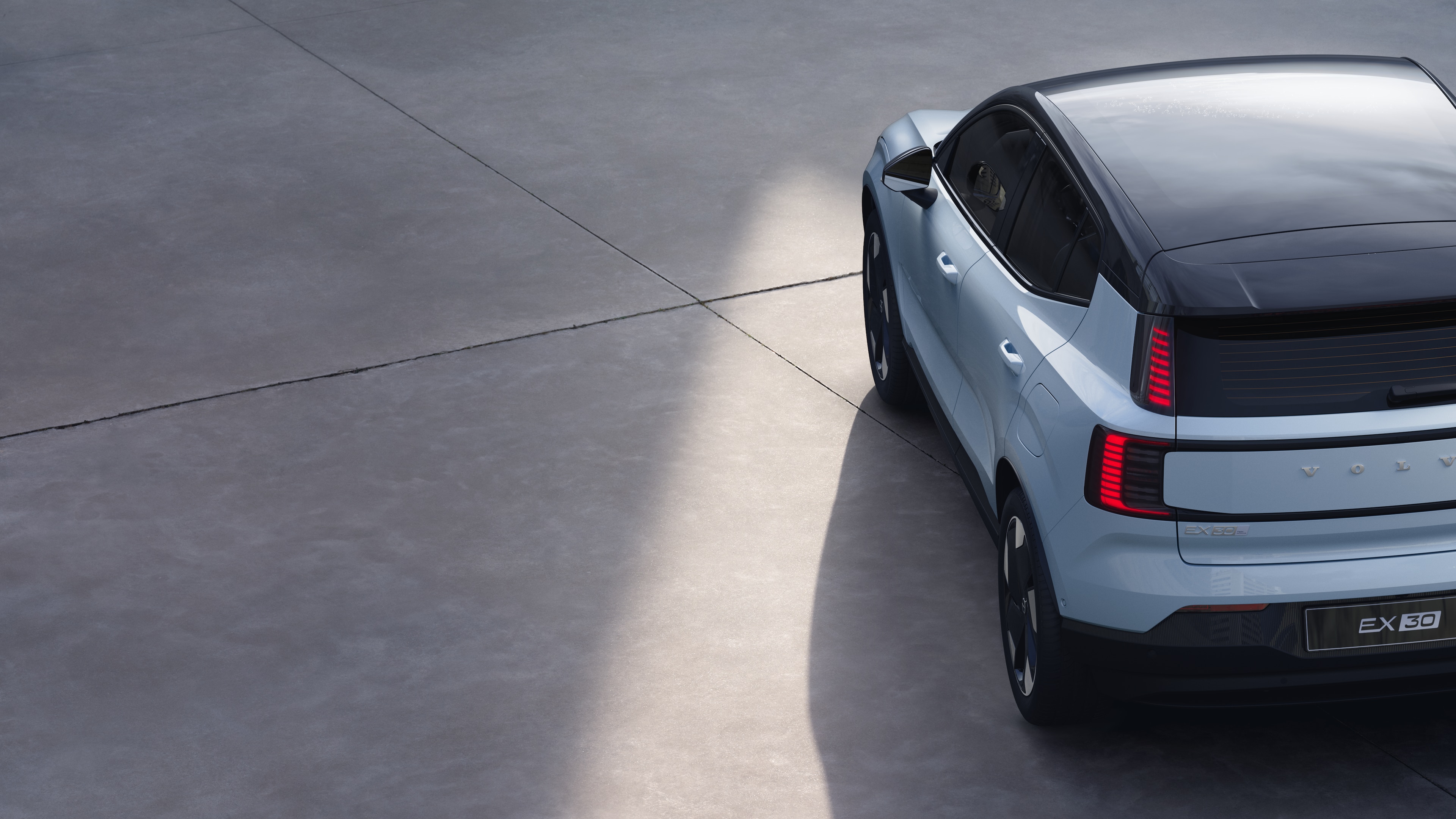 "Volvo" automobilis Trijų ketvirčių galinis vaizdas paprastame studijos fone, demonstruojantis galinių žibintų dizainą ir galinio lango konstrukciją išorės detalėms.