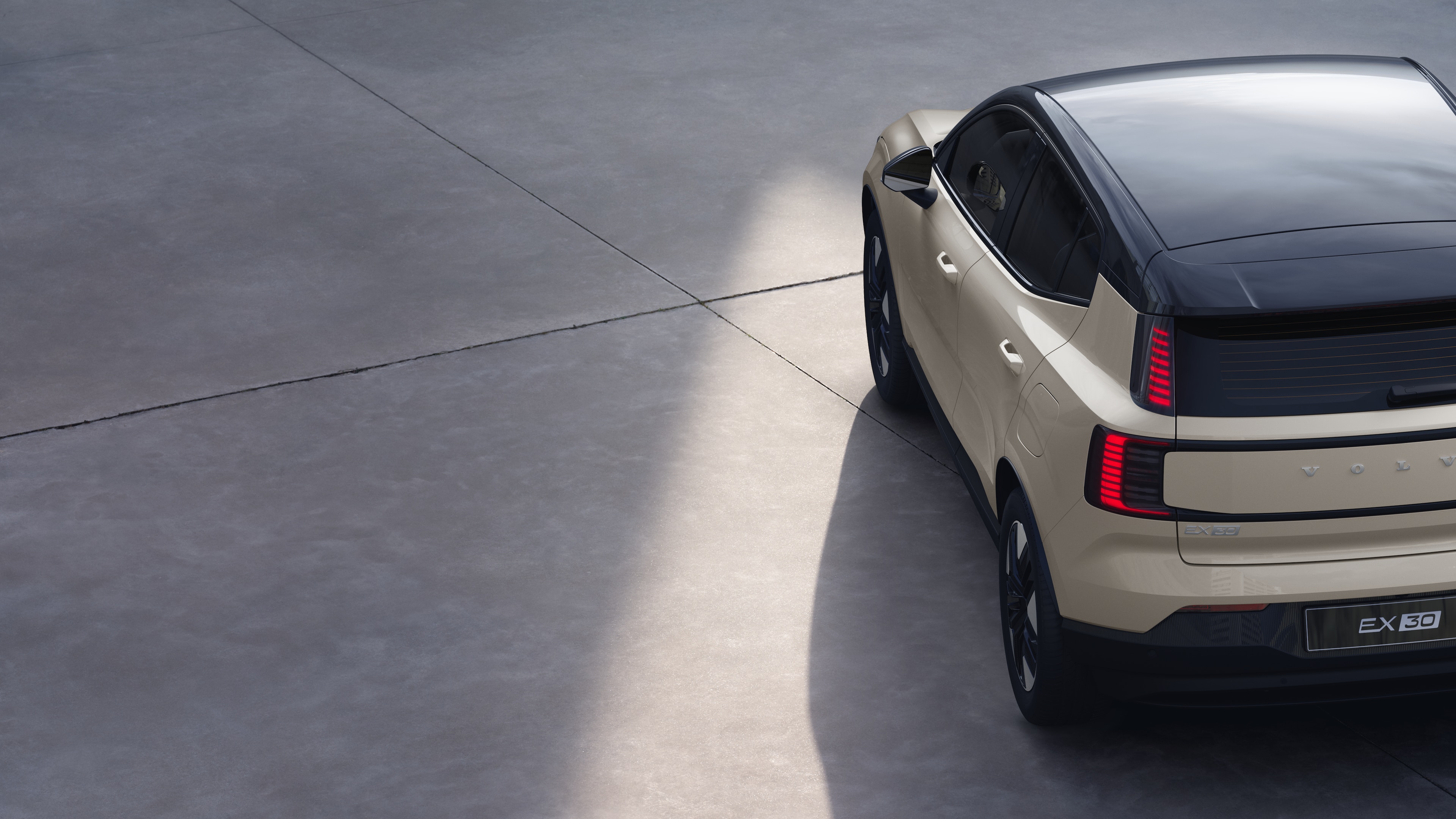 Volvo car three-quarter rear view on plain studio background, showcasing taillight design and rear window structure for exterior detailing.