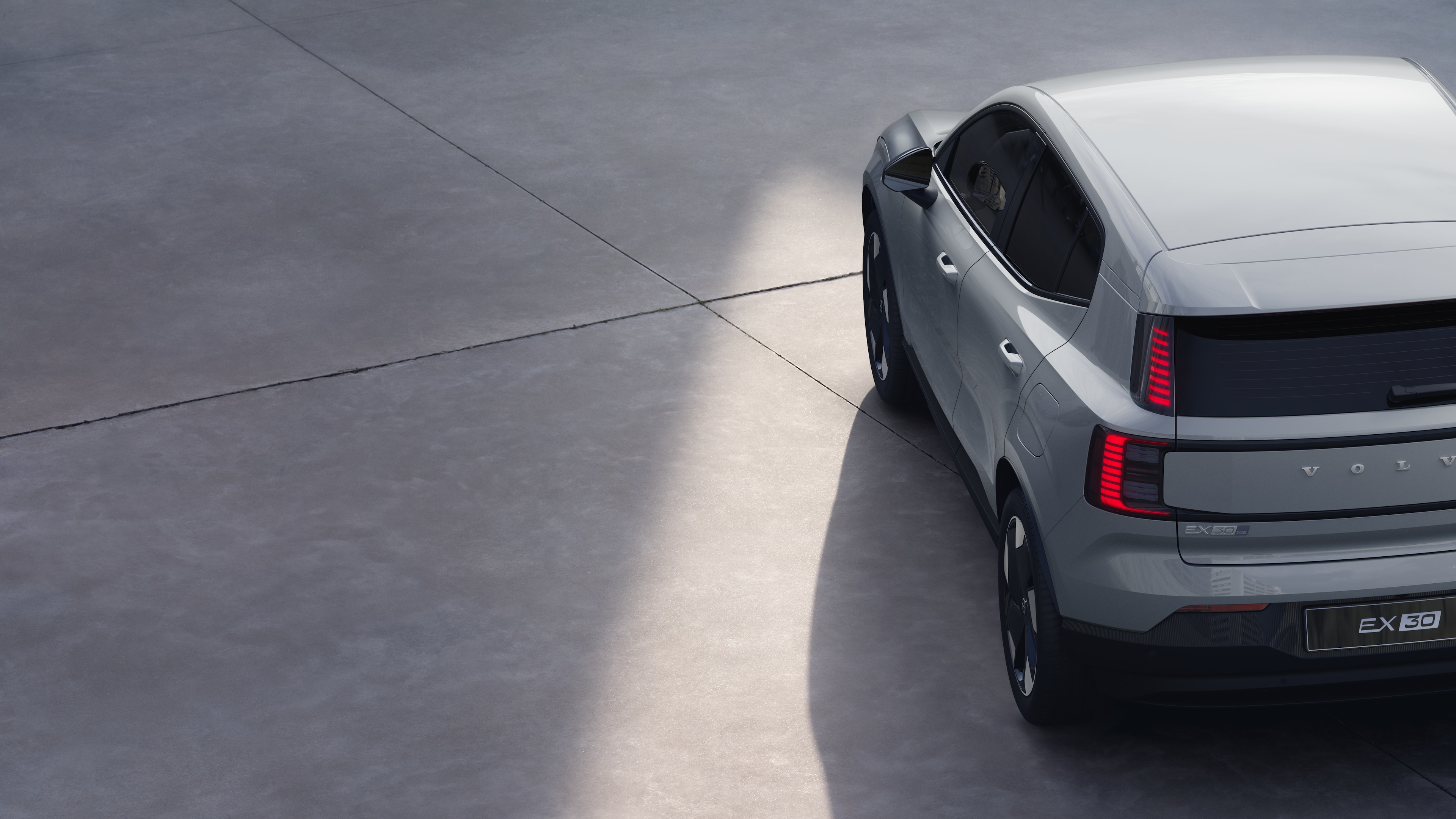 Vue arrière de trois quarts d’une Volvo sur un simple fond de studio, mettant en valeur le design des feux arrière et la structure de la lunette arrière pour les détails extérieurs.