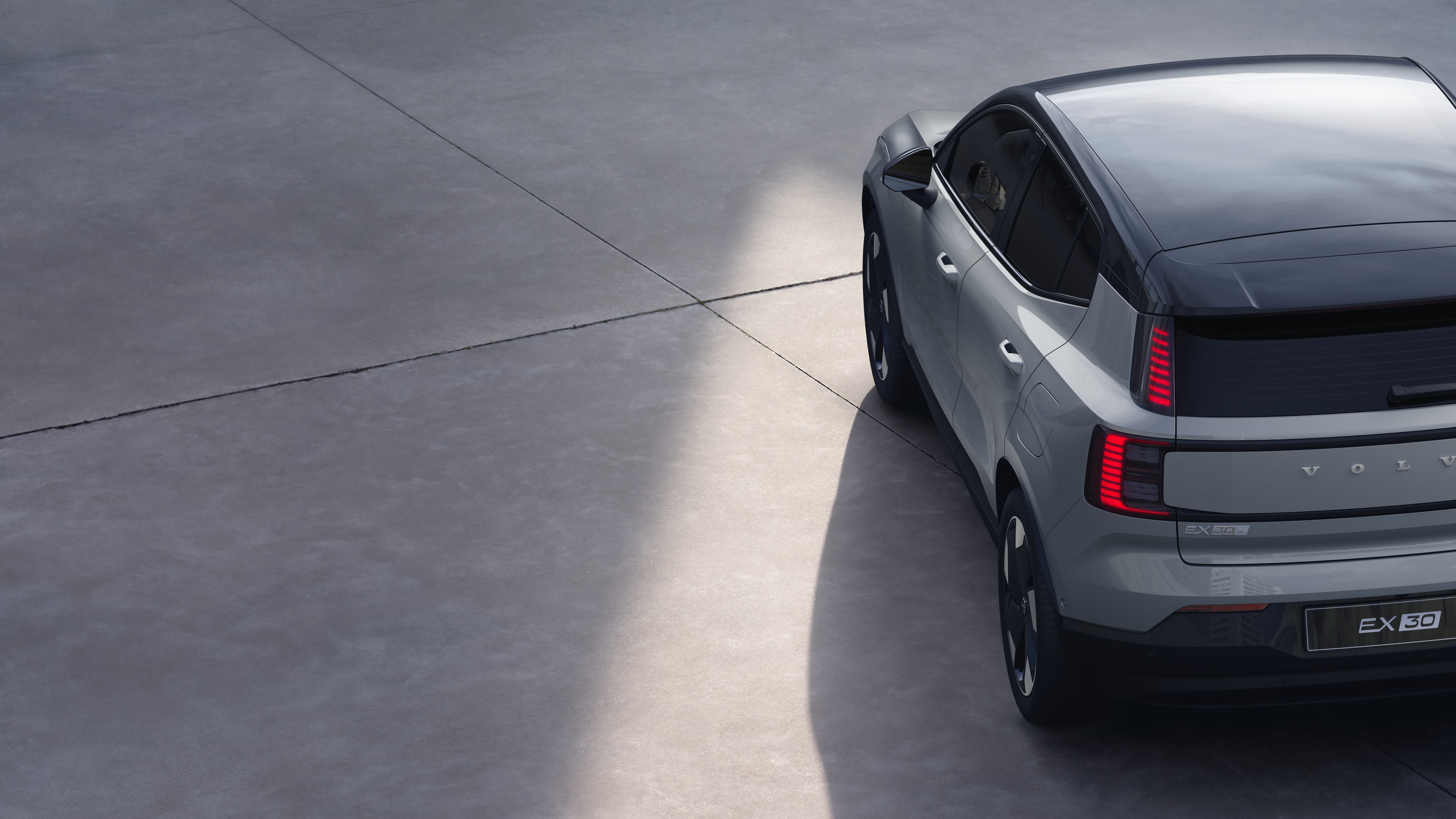 Vue arrière de trois quarts d’une Volvo sur un simple fond de studio, mettant en valeur le design des feux arrière et la structure de la lunette arrière pour les détails extérieurs.