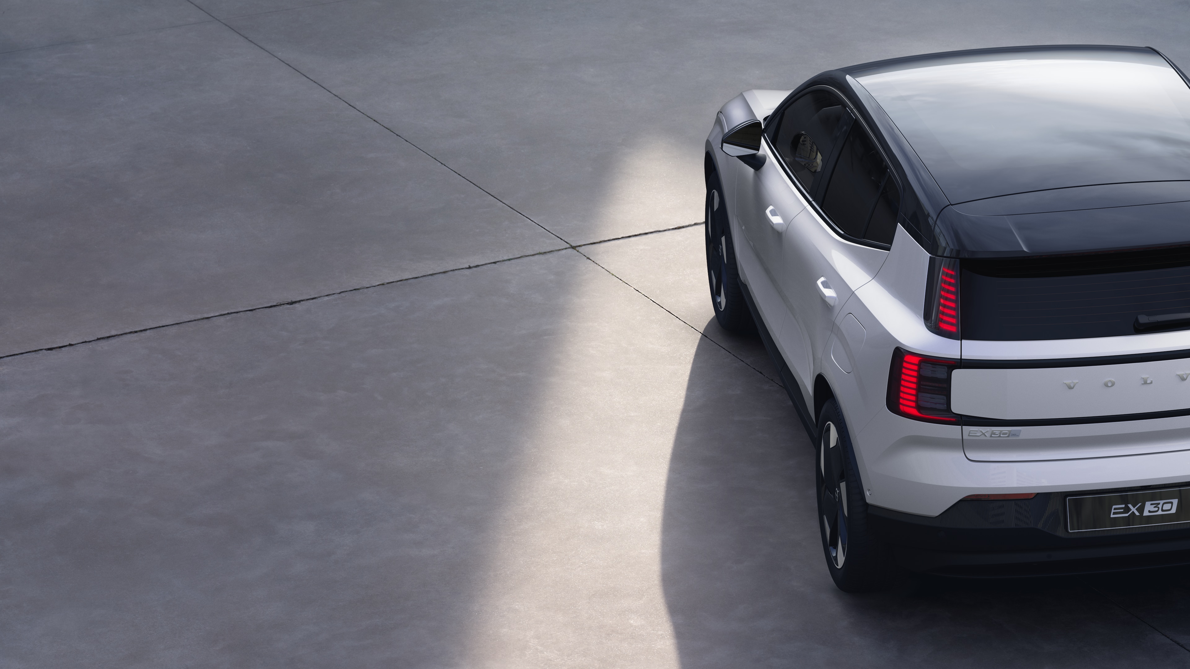 Vista trasera de tres cuartos del automóvil Volvo sobre fondo de estudio liso, que muestra el diseño de las luces traseras y la estructura de la ventana trasera para los detalles exteriores.