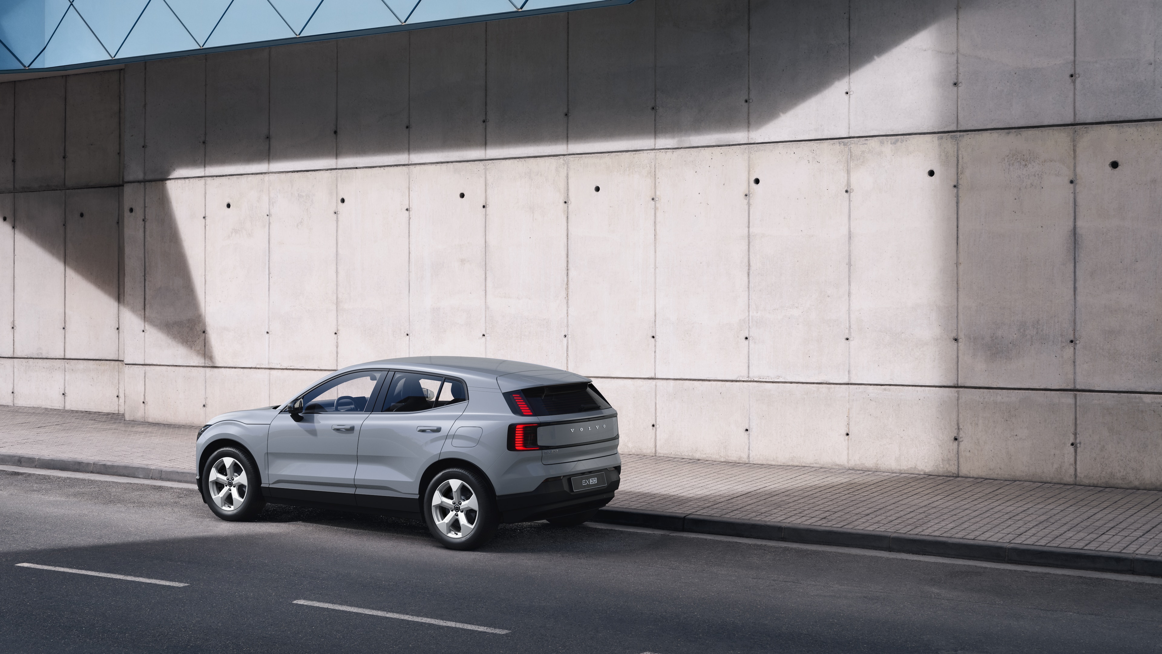 Dreiviertelansicht eines Volvo im Heck, der vor einer Betonwand auf einer städtischen Straße geparkt ist.
