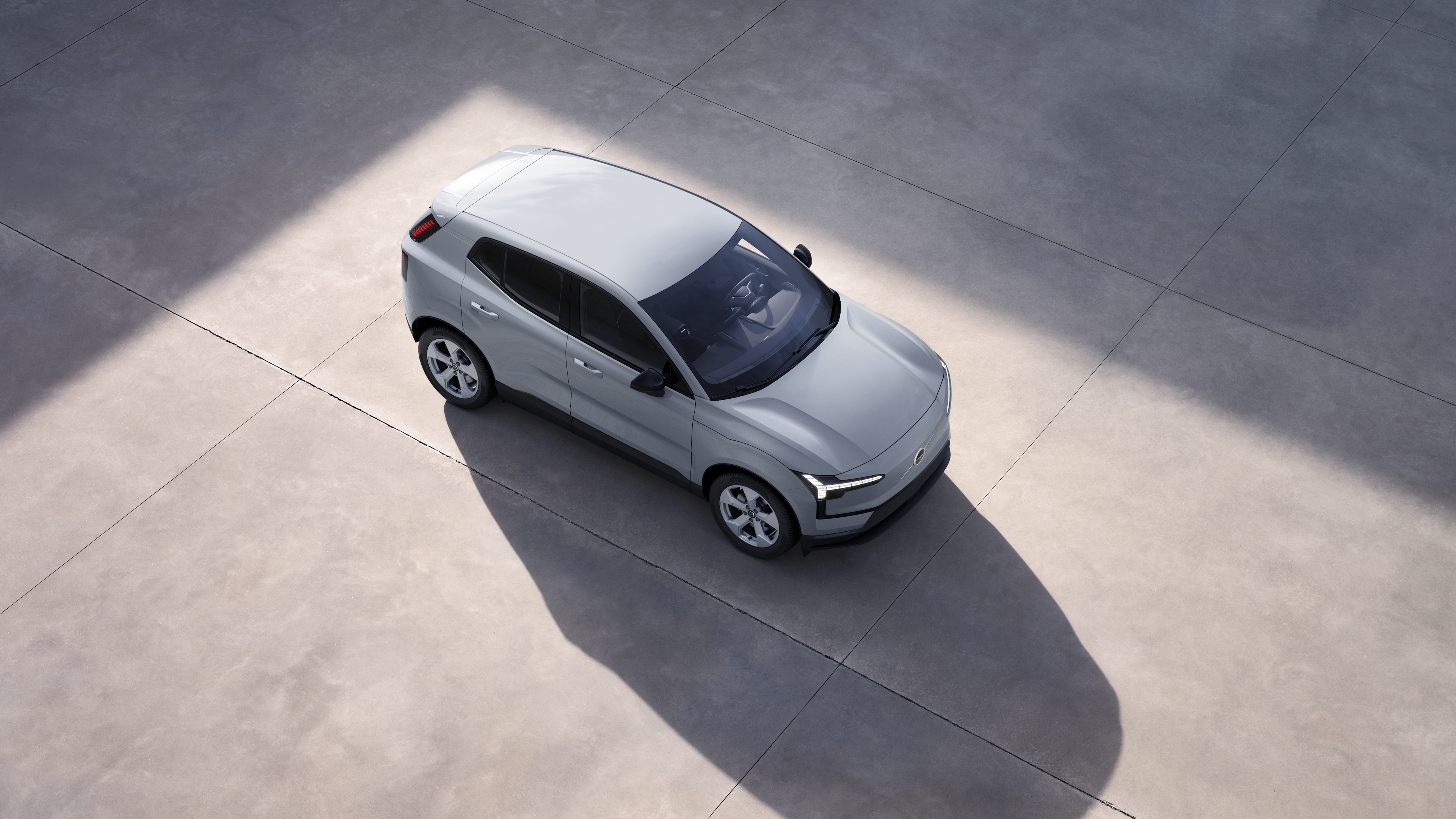 El exterior de un coche Volvo se muestra desde arriba con un fondo de estudio liso.